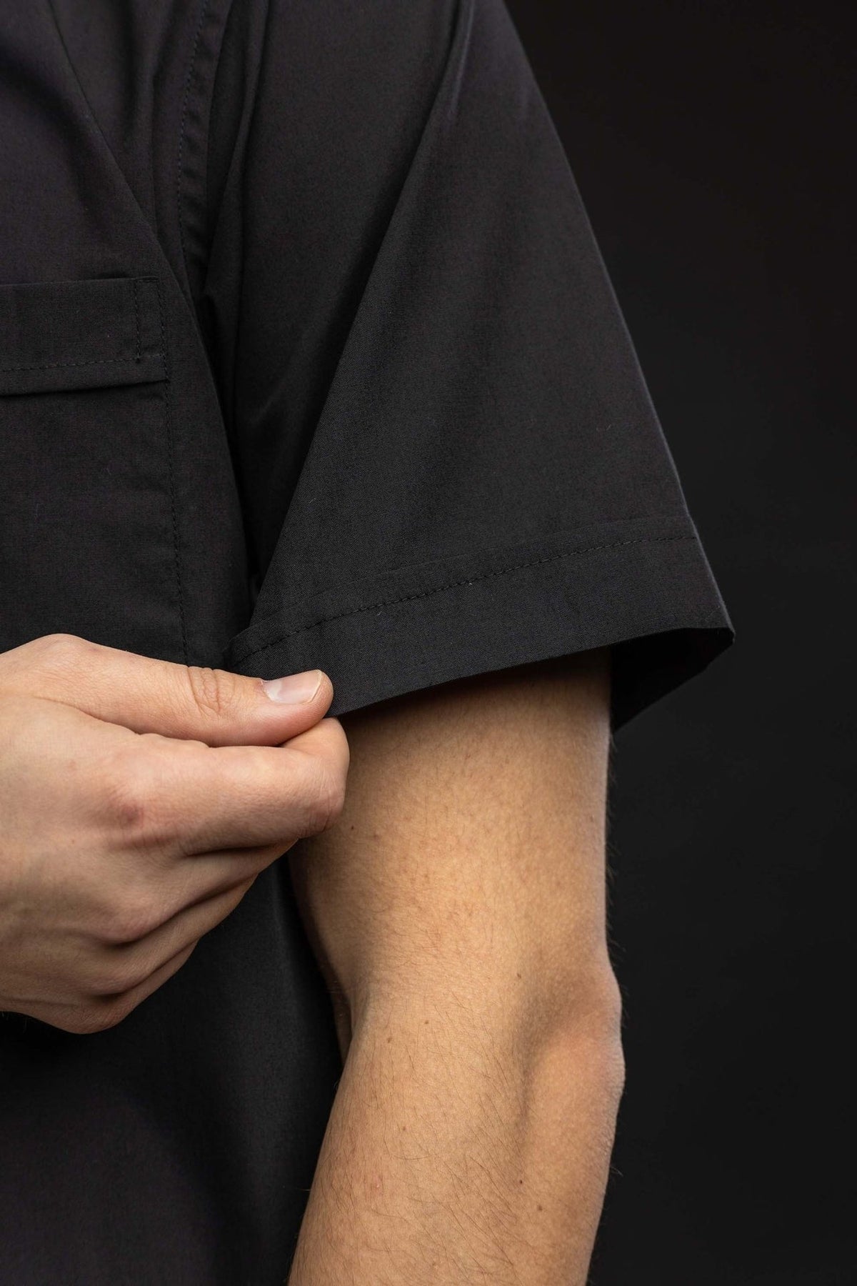 Camisa clerical preta com detalhe da manga curta e barra pespontada