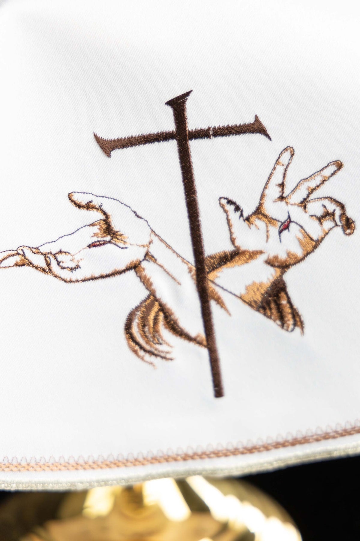 Véu de âmbula branco em close-up do bordado franciscano com cruz