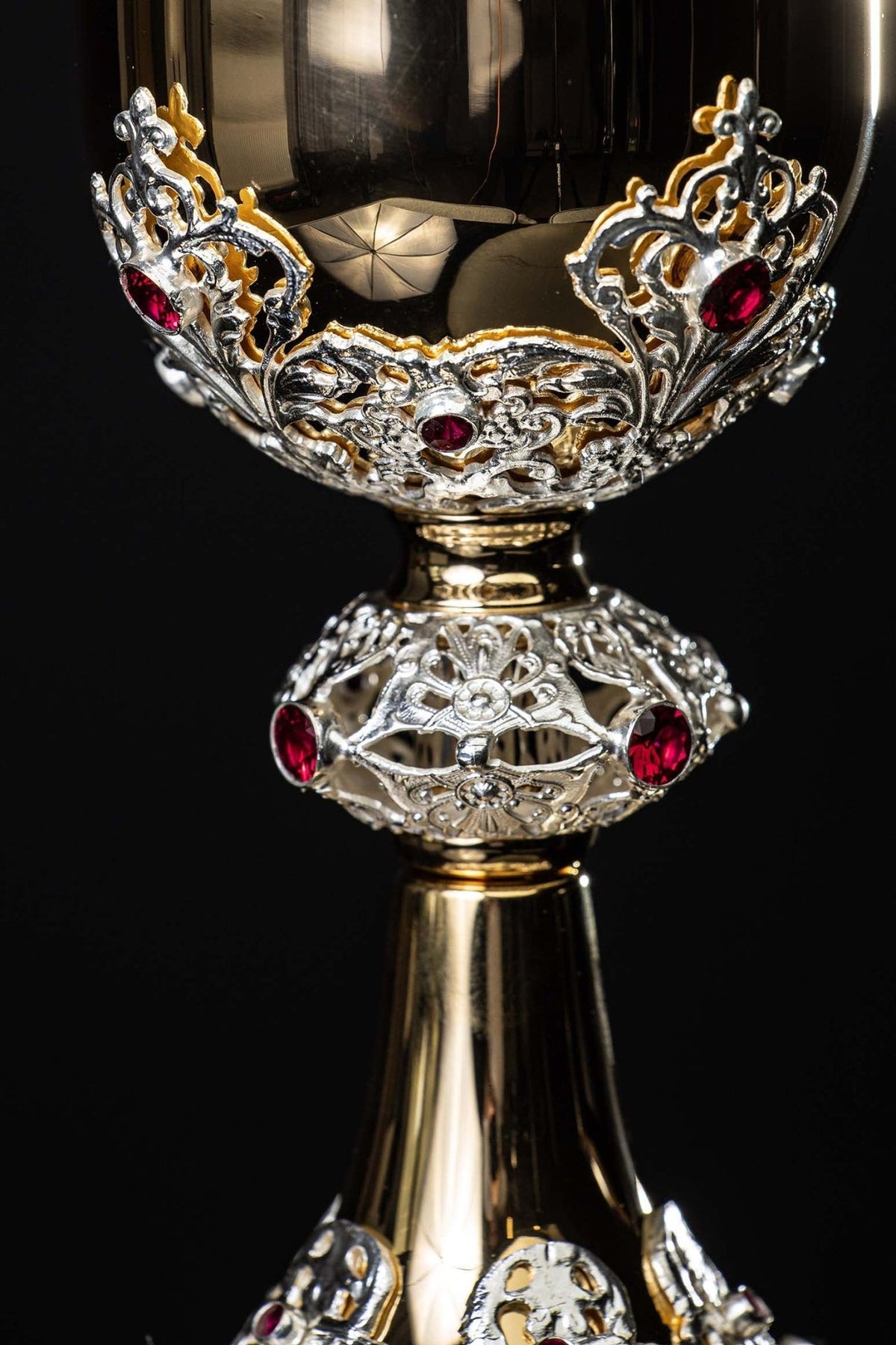 Cálice dourado com close-up da copa e arabescos prateados com rubis