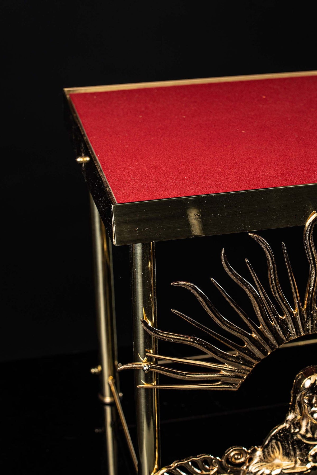 Suporte de ostensório em latão dourado, close do tampo vermelho e da estrutura lateral