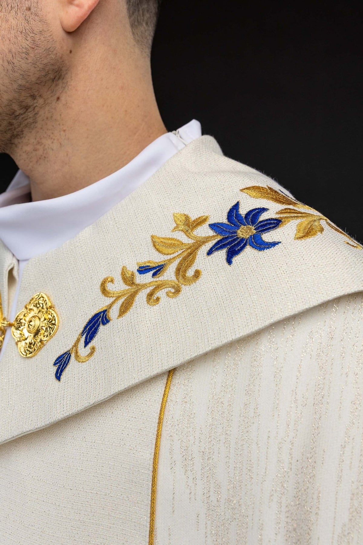 Capa de asperges com close-up do fecho dourado e bordado floral azul
