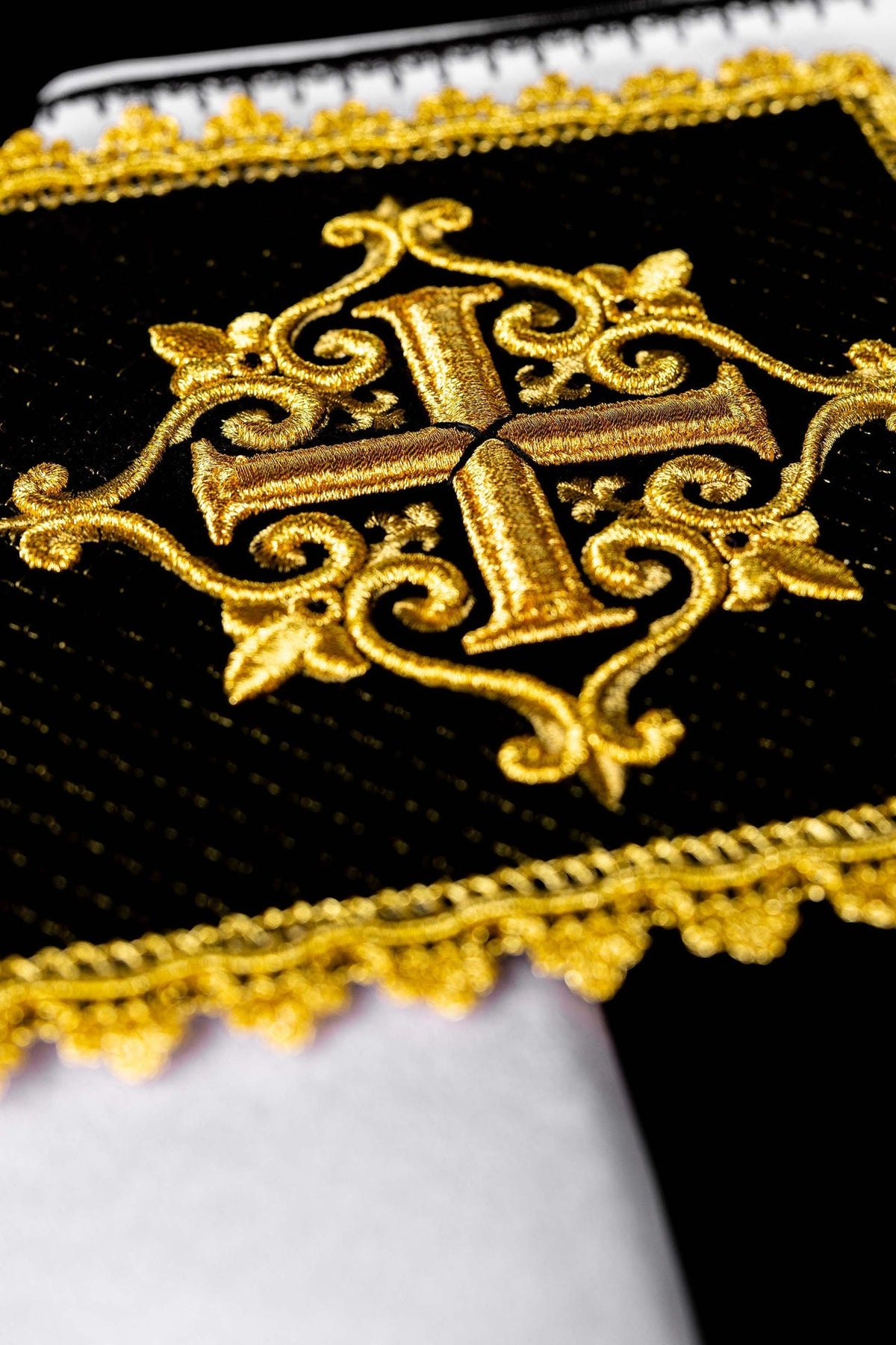 Alfaias litúrgicas em close-up, bordado dourado ornamental sobre veludo preto