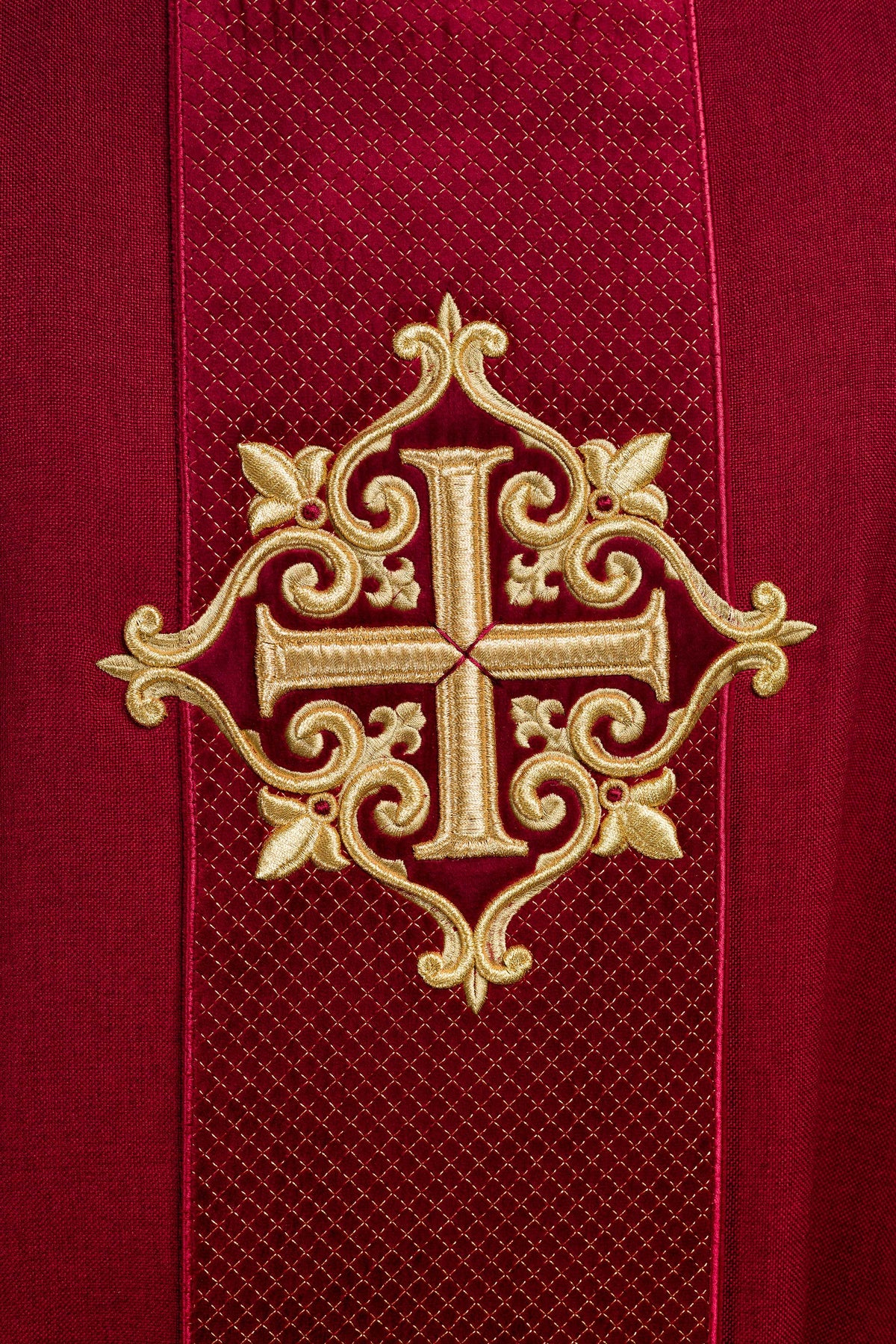 Casula vermelha em close-up, mostrando faixa texturizada e cruz bordada em dourado