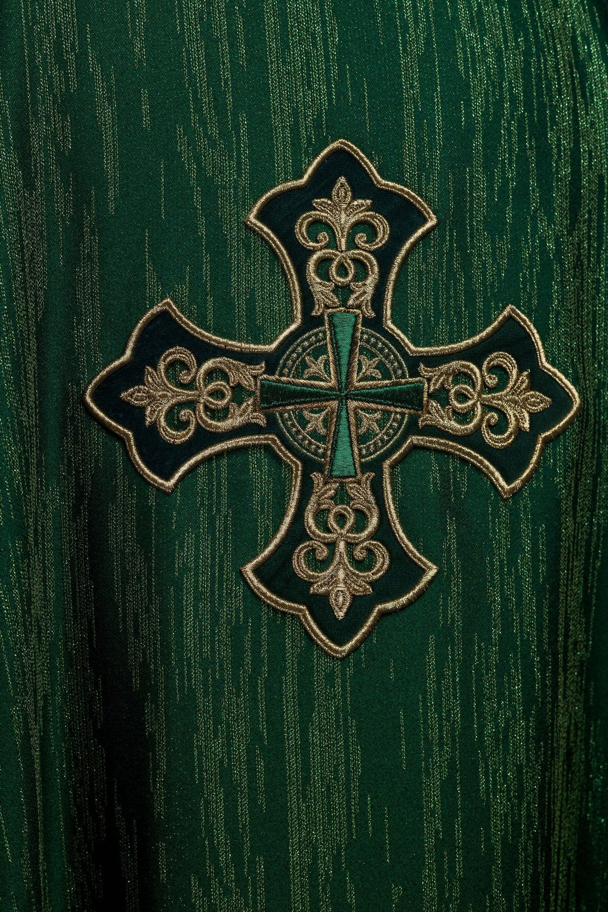 Casula verde com cruz bordada, close-up do bordado dourado sobre tecido ornamental