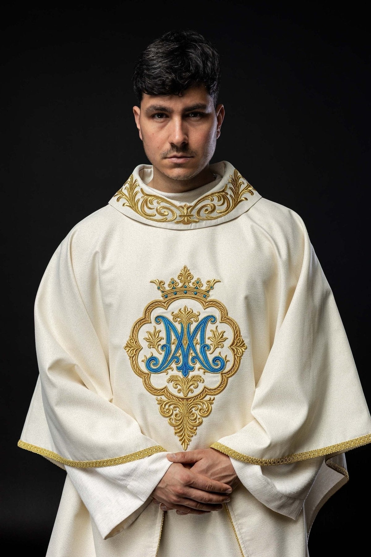 Casula mariana com brasão e coroa bordados, vista frontal, marfim ecru, com monograma azul e detalhes dourados