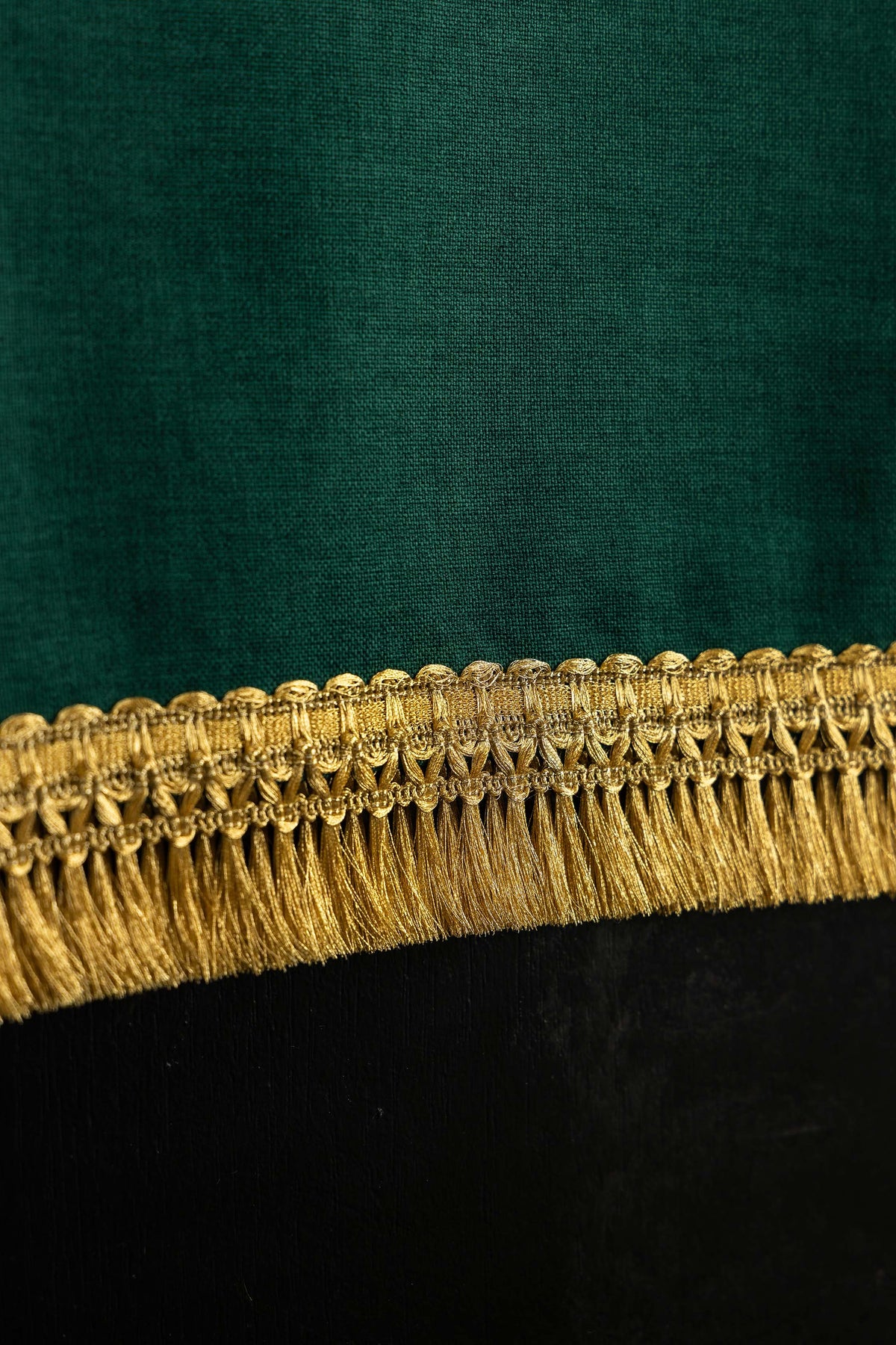 Pano de ambão verde, close-up da franja dourada na borda inferior