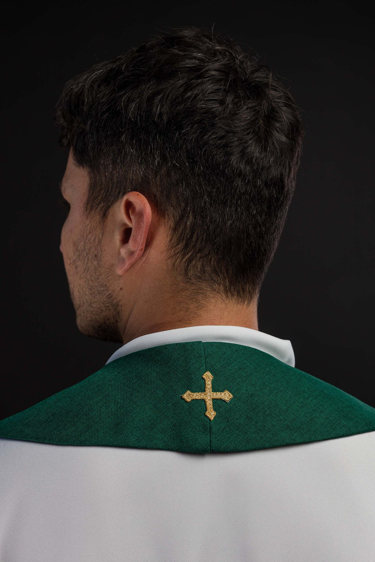 Estola verde vista por trás, com cruz dourada bordada na nuca
