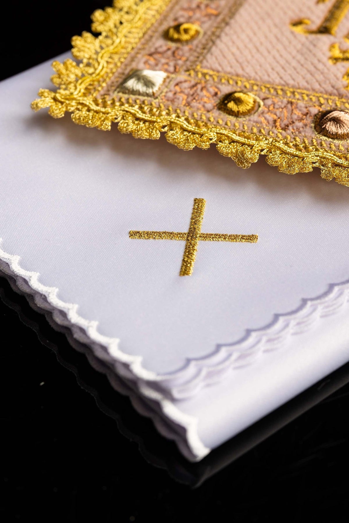 Alfaias litúrgicas com acabamento dourado e cruz bordada