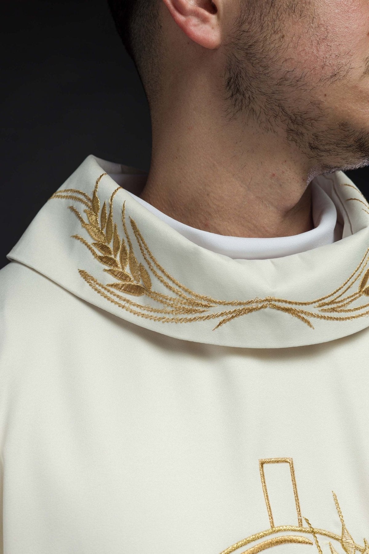 Casula creme em close-up da gola, com bordado dourado de espigas