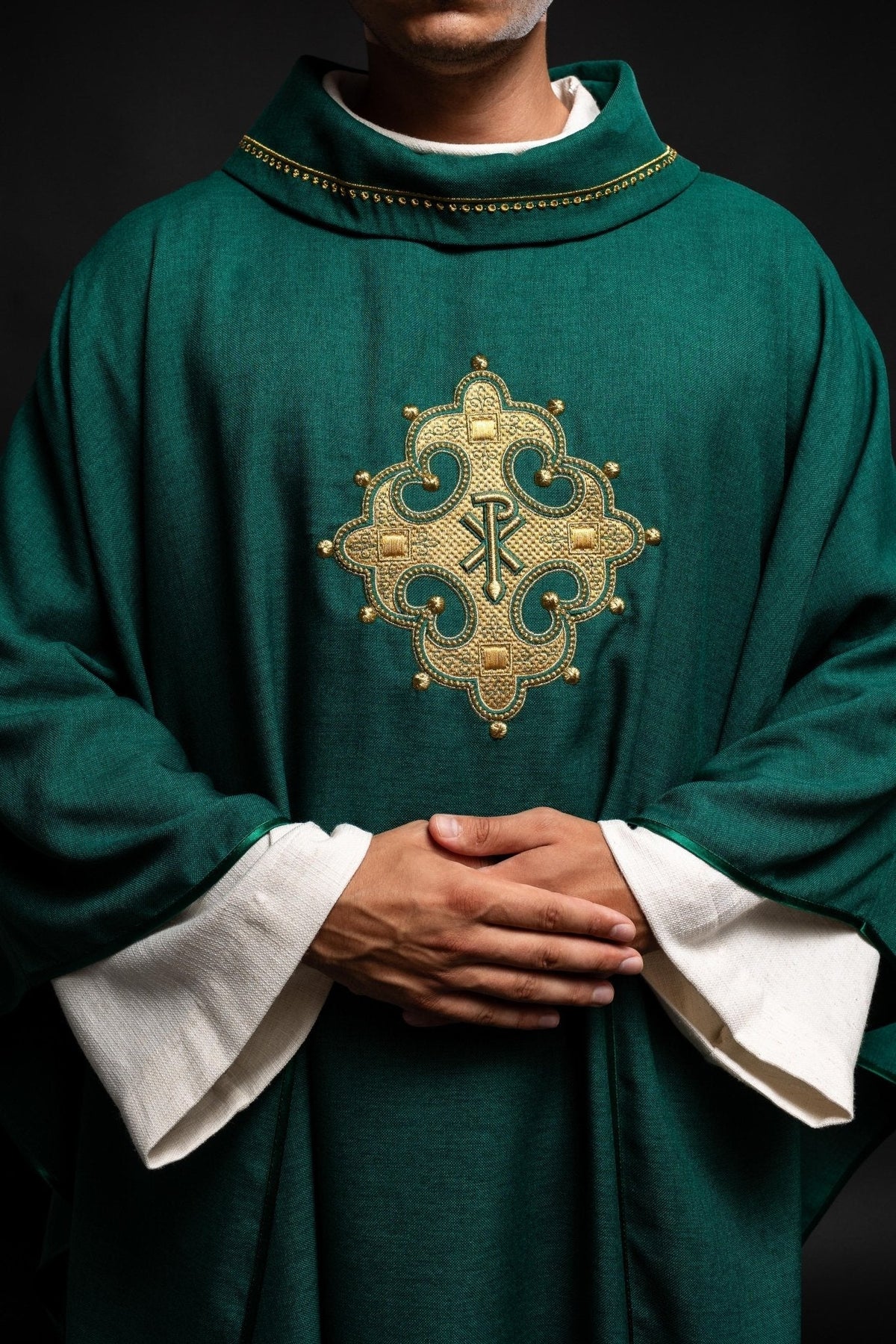 Casula verde com cruz bordada, detalhe frontal do bordado dourado