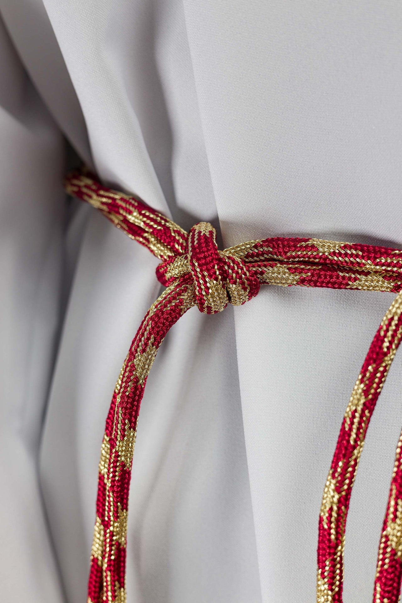 Cíngulo litúrgico vermelho e dourado