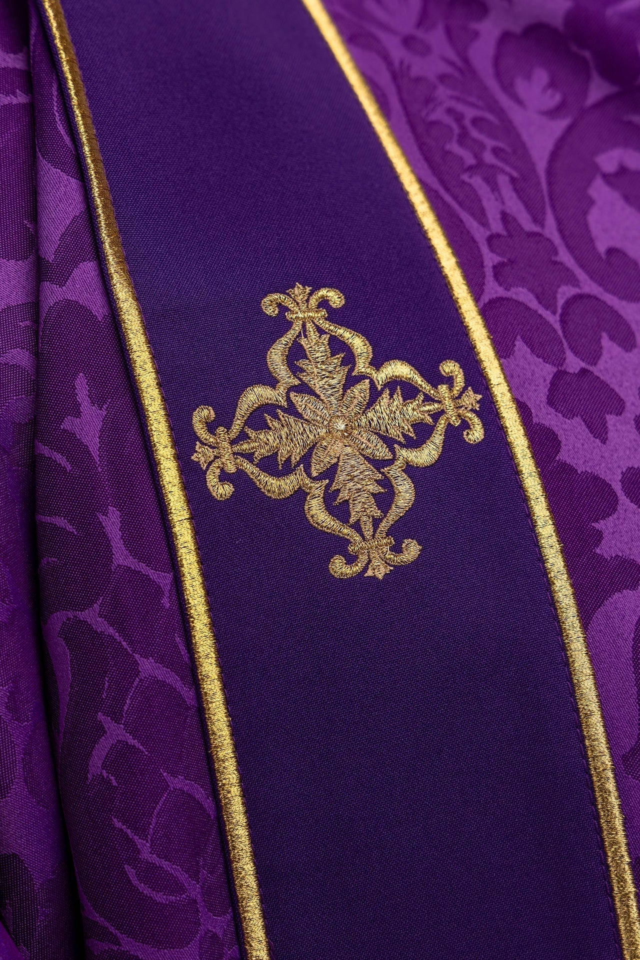 Dalmática roxa com faixas e cruzes bordadas douradas em jacquard para Advento e Quaresma.