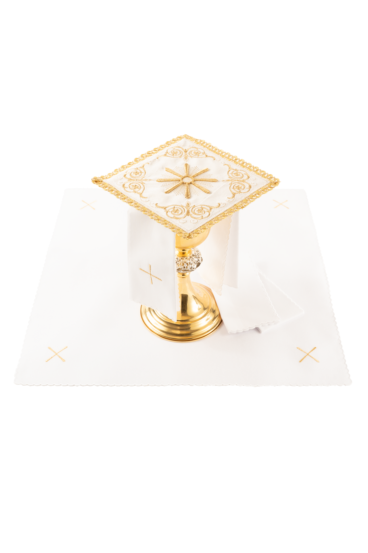 Conjunto de alfaias litúrgicas creme: pala de veludo com bordado do sol eucarístico sobre um cálice dourado, corporal branco com cruzes, sanguíneo e manutérgio.