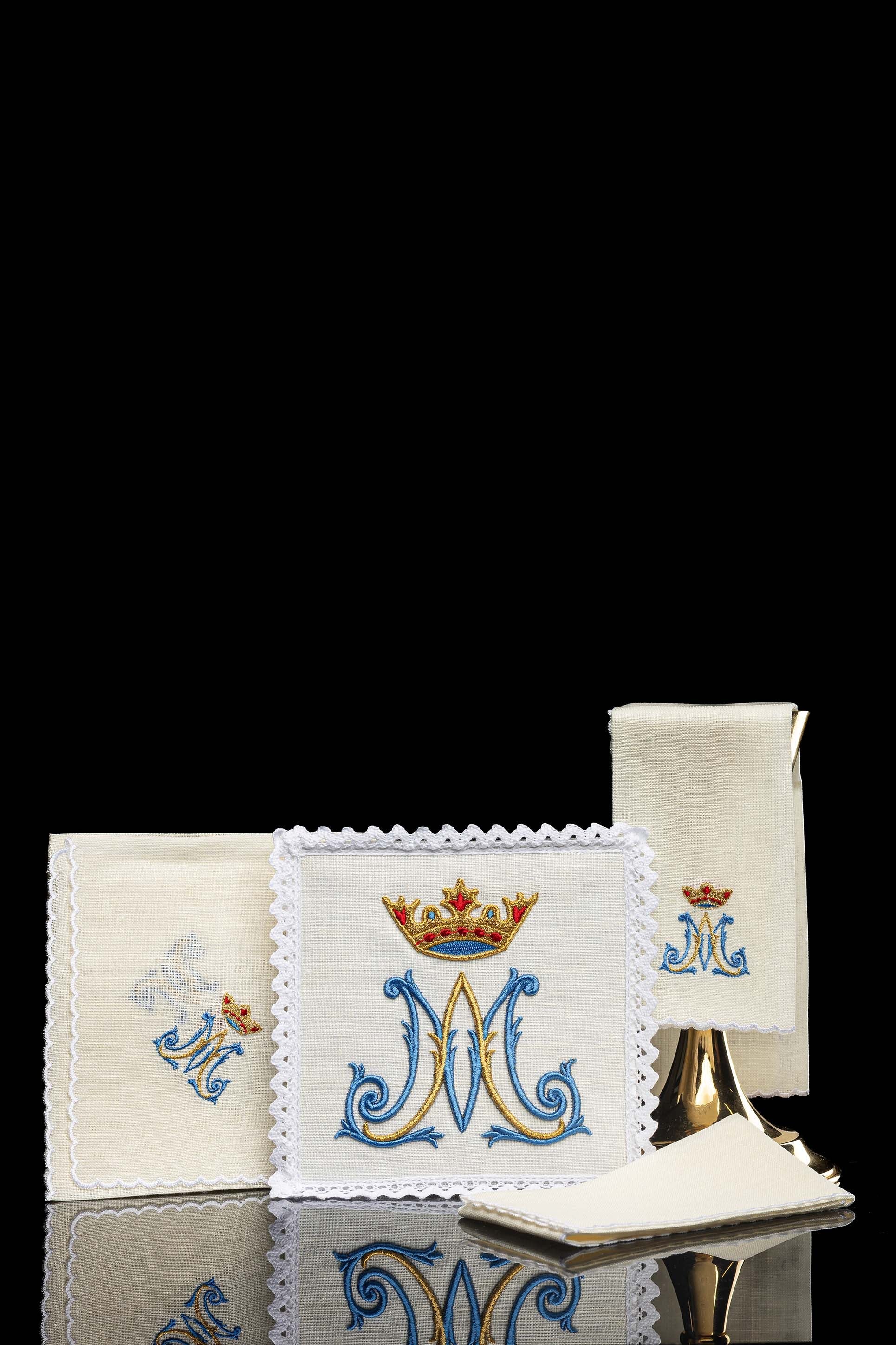 Conjunto de alfaias litúrgicas em linho com bordado mariano, incluindo pala, corporal, sanguíneo e manutérgio.