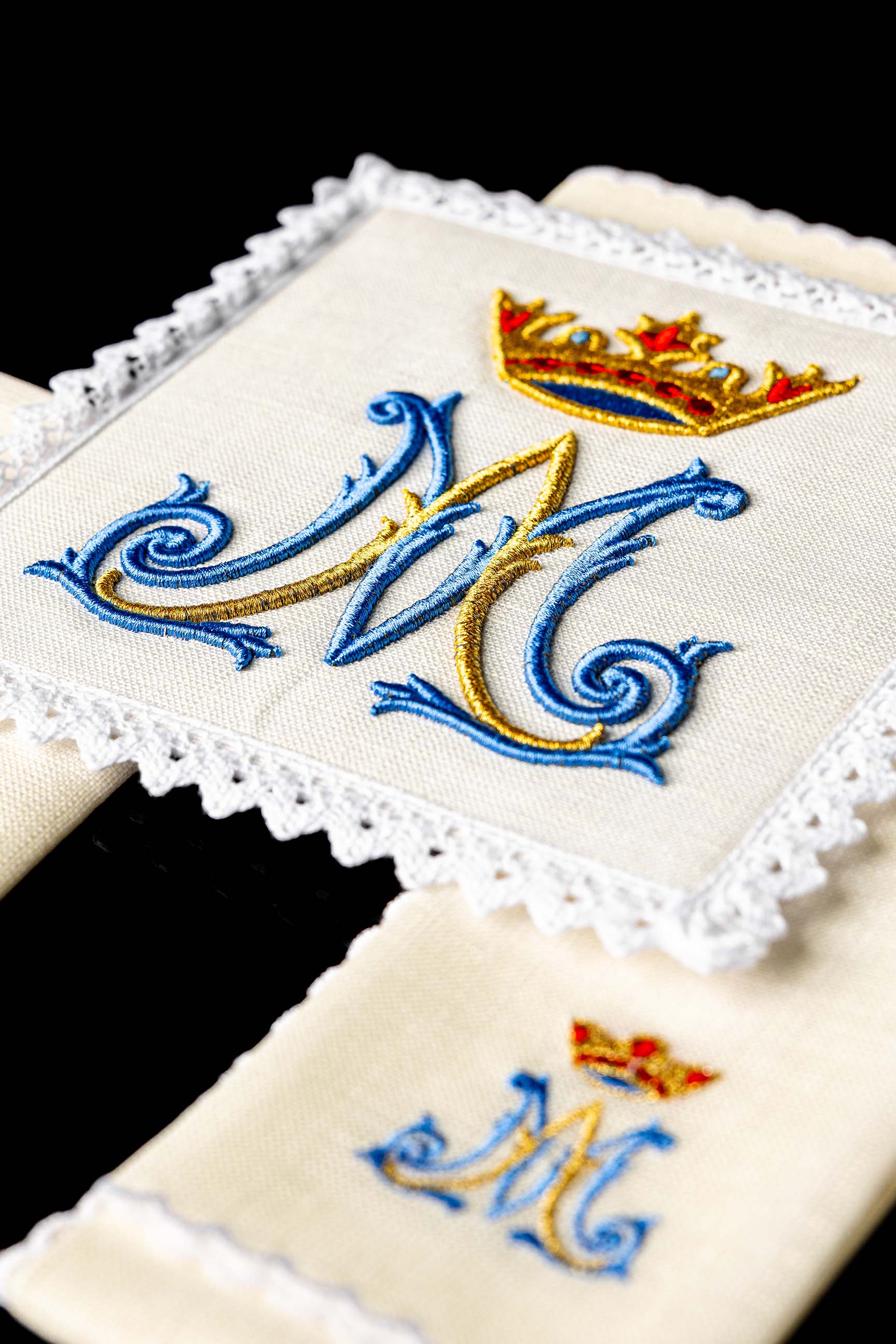 Conjunto de alfaias litúrgicas em linho com bordado mariano, incluindo pala, corporal, sanguíneo e manutérgio.