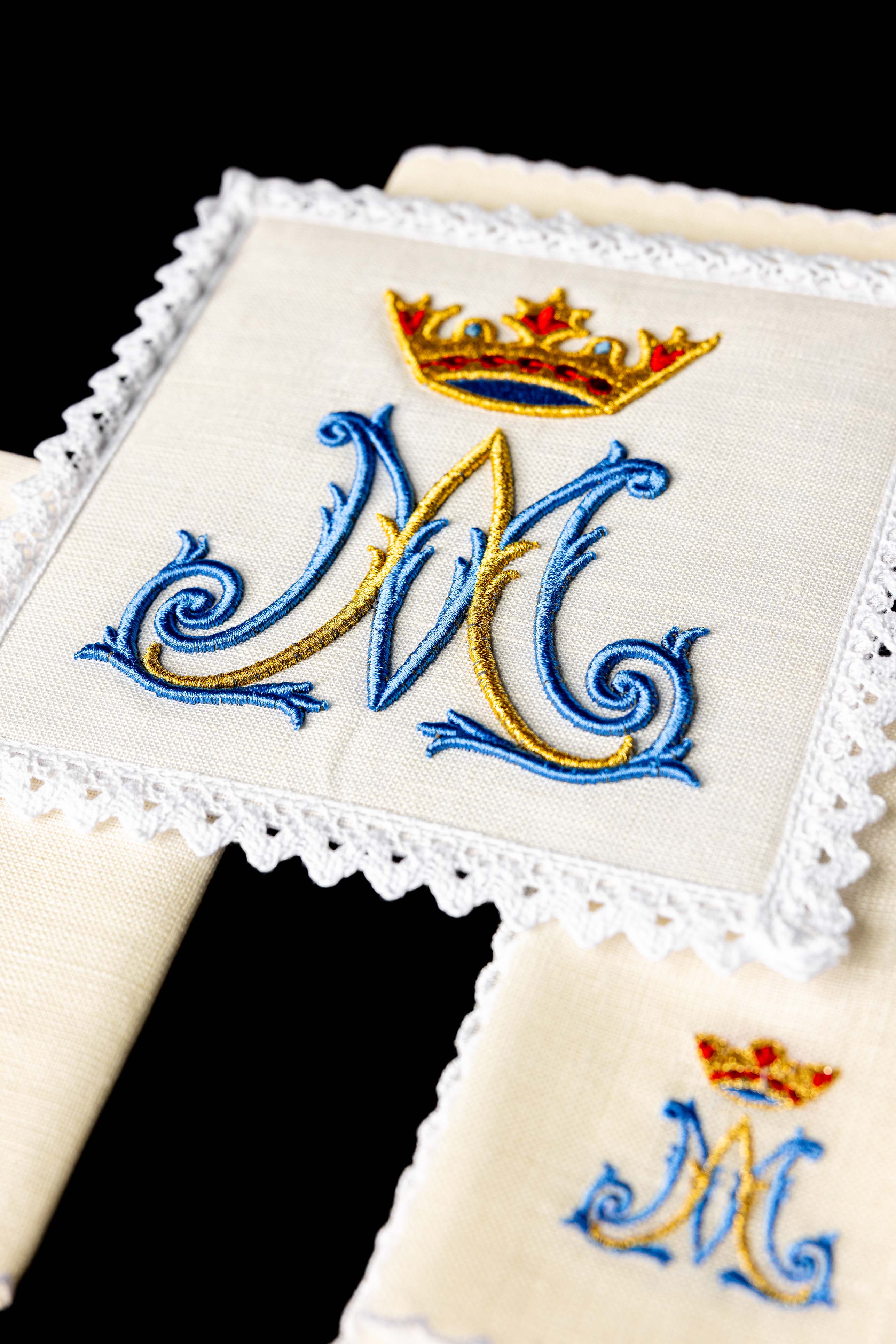 Conjunto de alfaias litúrgicas em linho com bordado mariano, incluindo pala, corporal, sanguíneo e manutérgio.