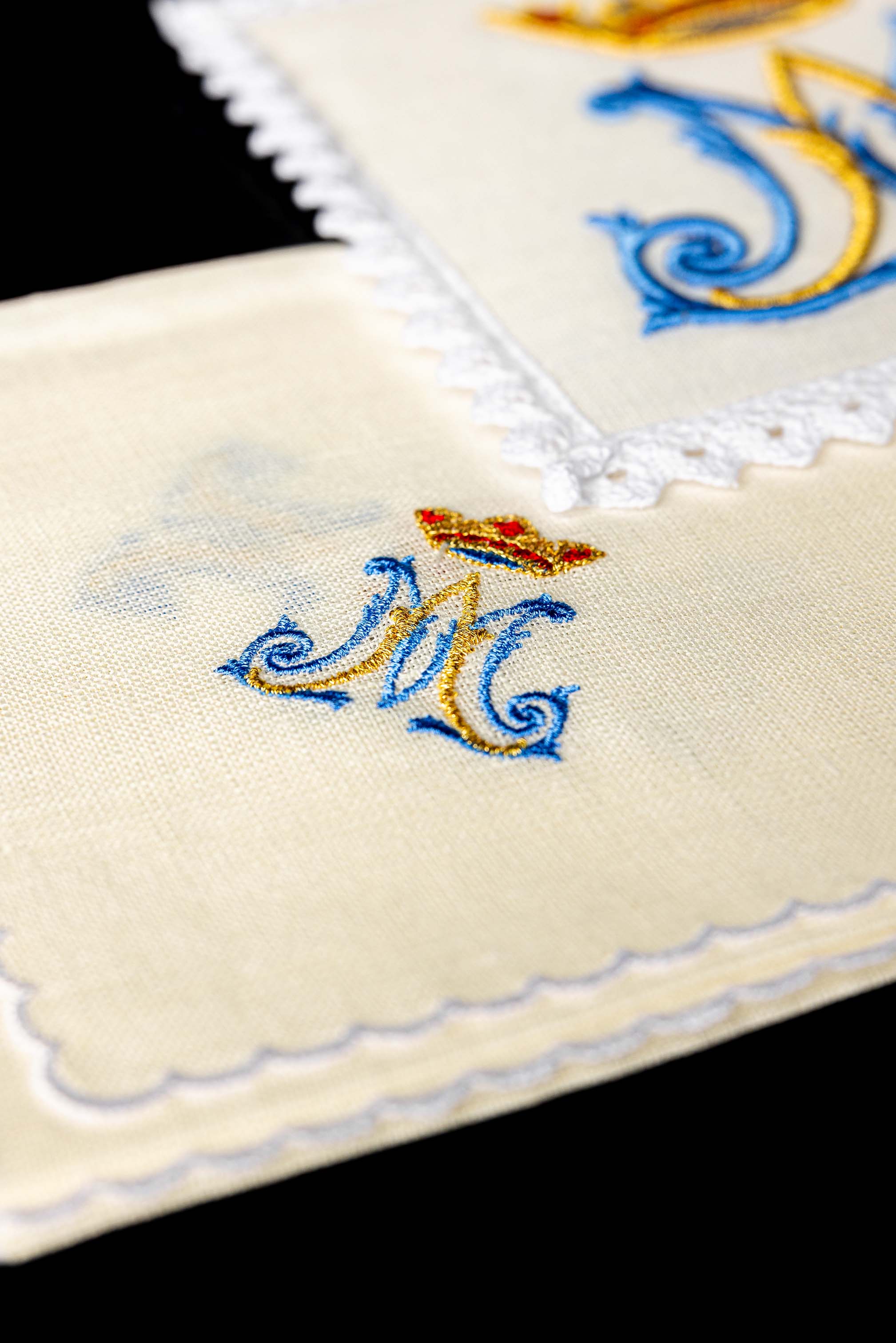 Conjunto de alfaias litúrgicas em linho com bordado mariano, incluindo pala, corporal, sanguíneo e manutérgio.