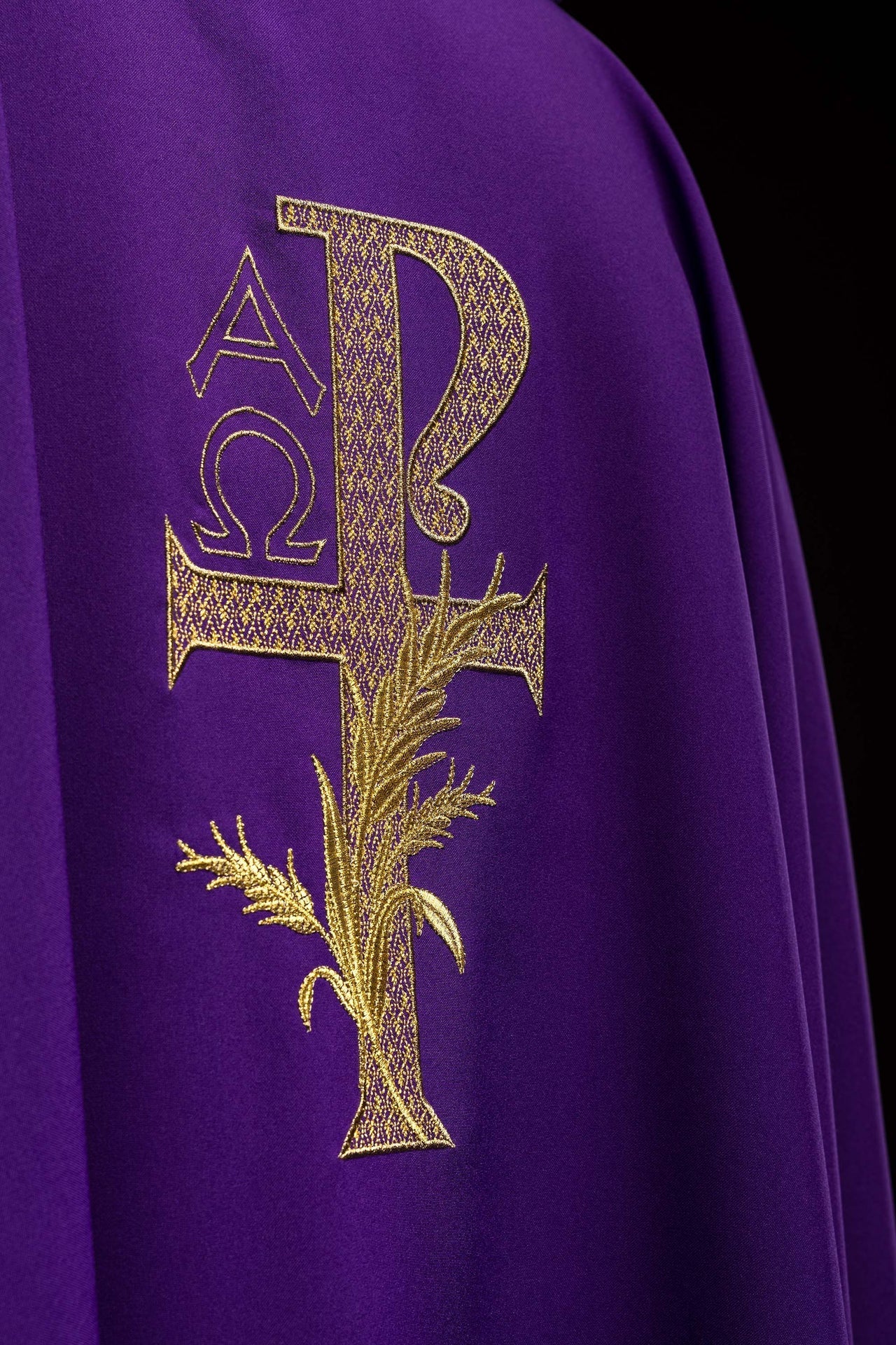 Casula bordada com símbolo Alfa e Ômega e gola larga roxa