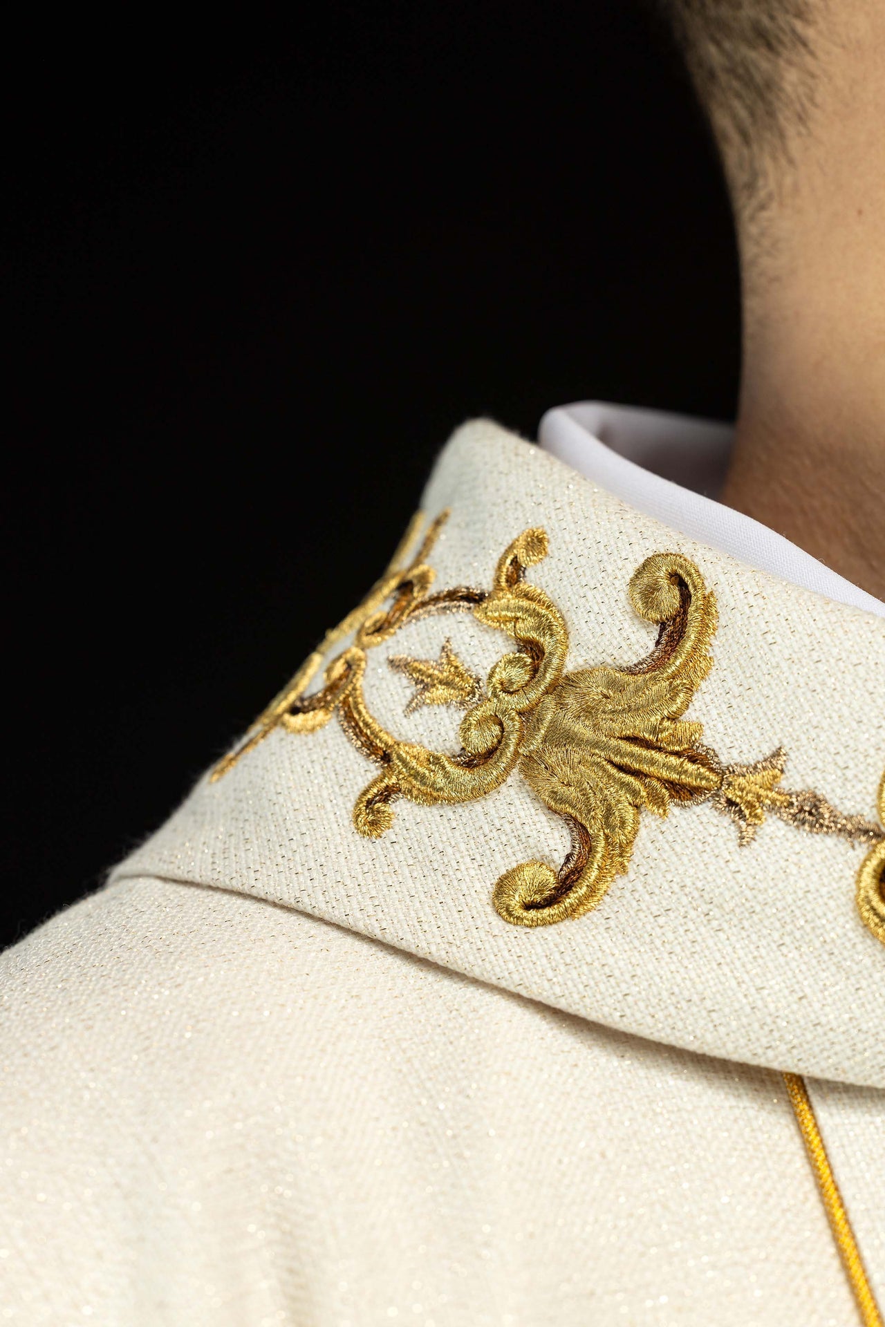 Casula creme com bordado de Nossa Senhora do Rosário e detalhes dourados.