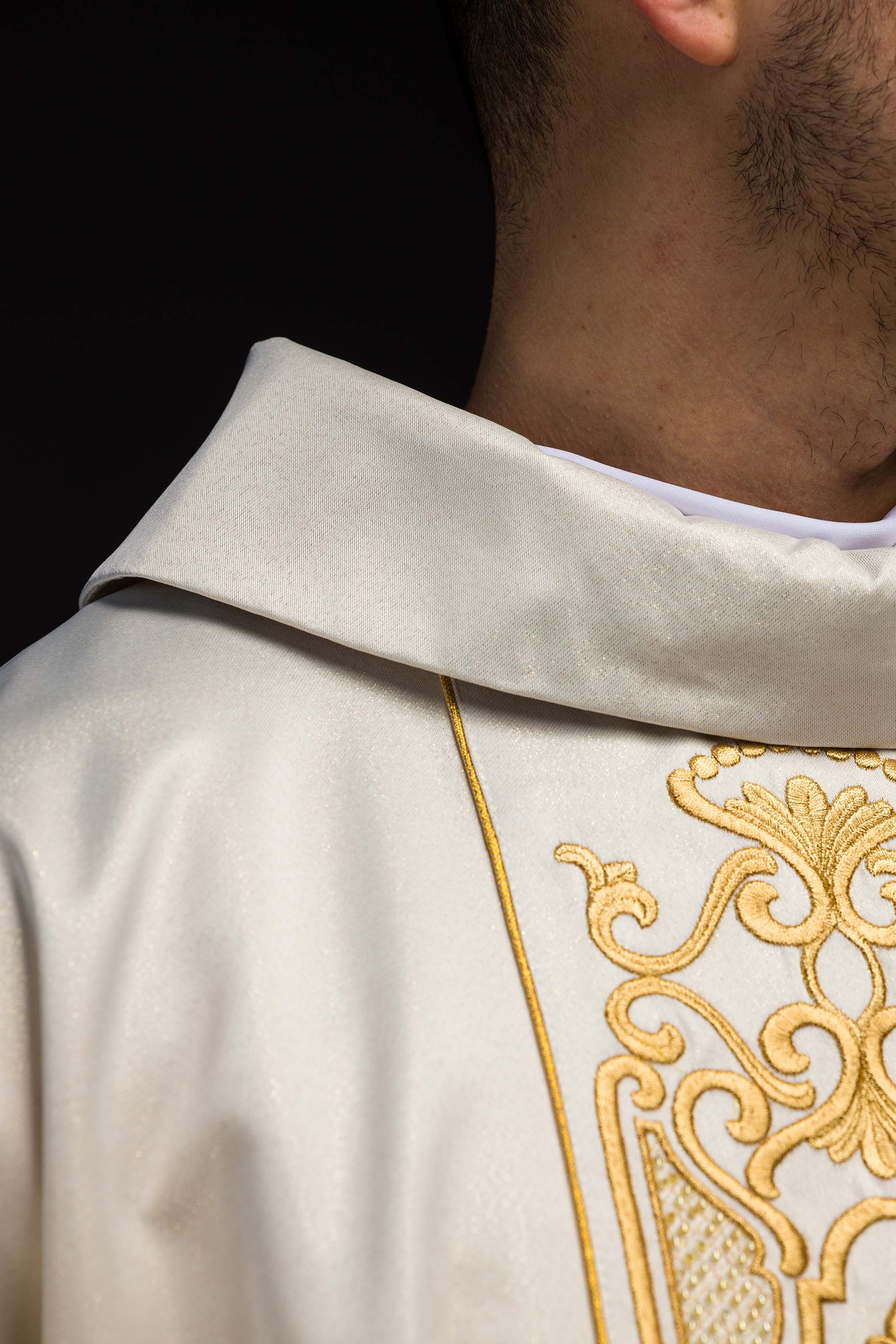 Casula de tecido cintilante com rico bordado dourado na faixa