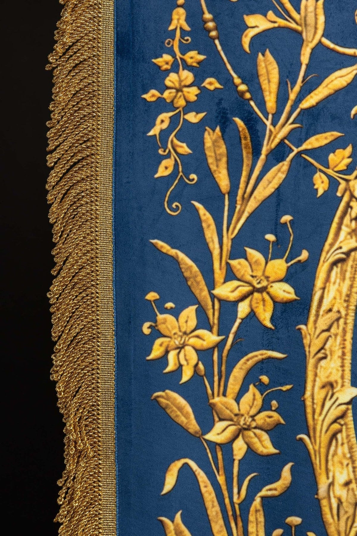 Estandarte azul, close-up do monograma mariano dourado no verso
