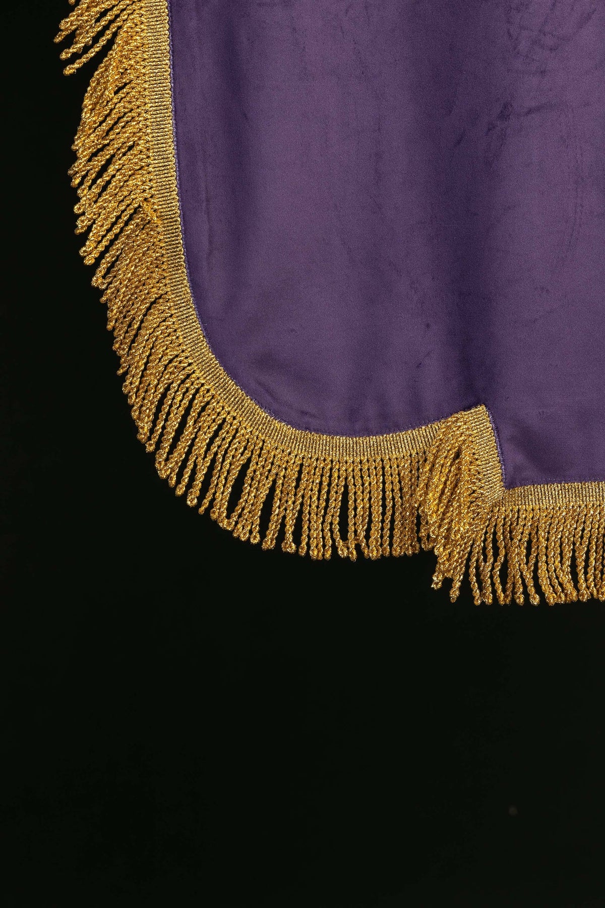 Estandarte roxo, close-up da franja dourada no contorno inferior curvo