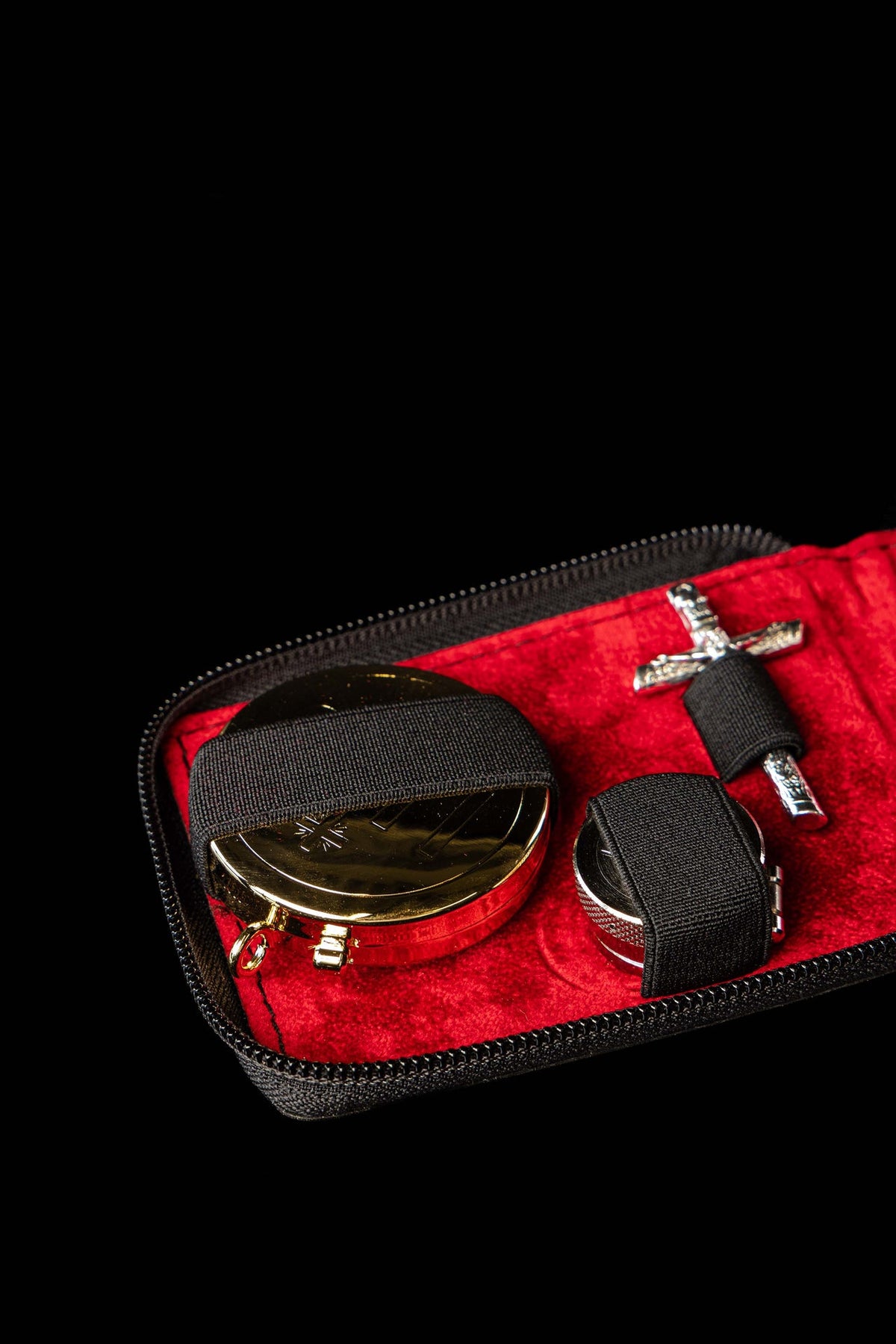 Bolsa litúrgica aberta mostrando patena dourada, cálice e crucifixo