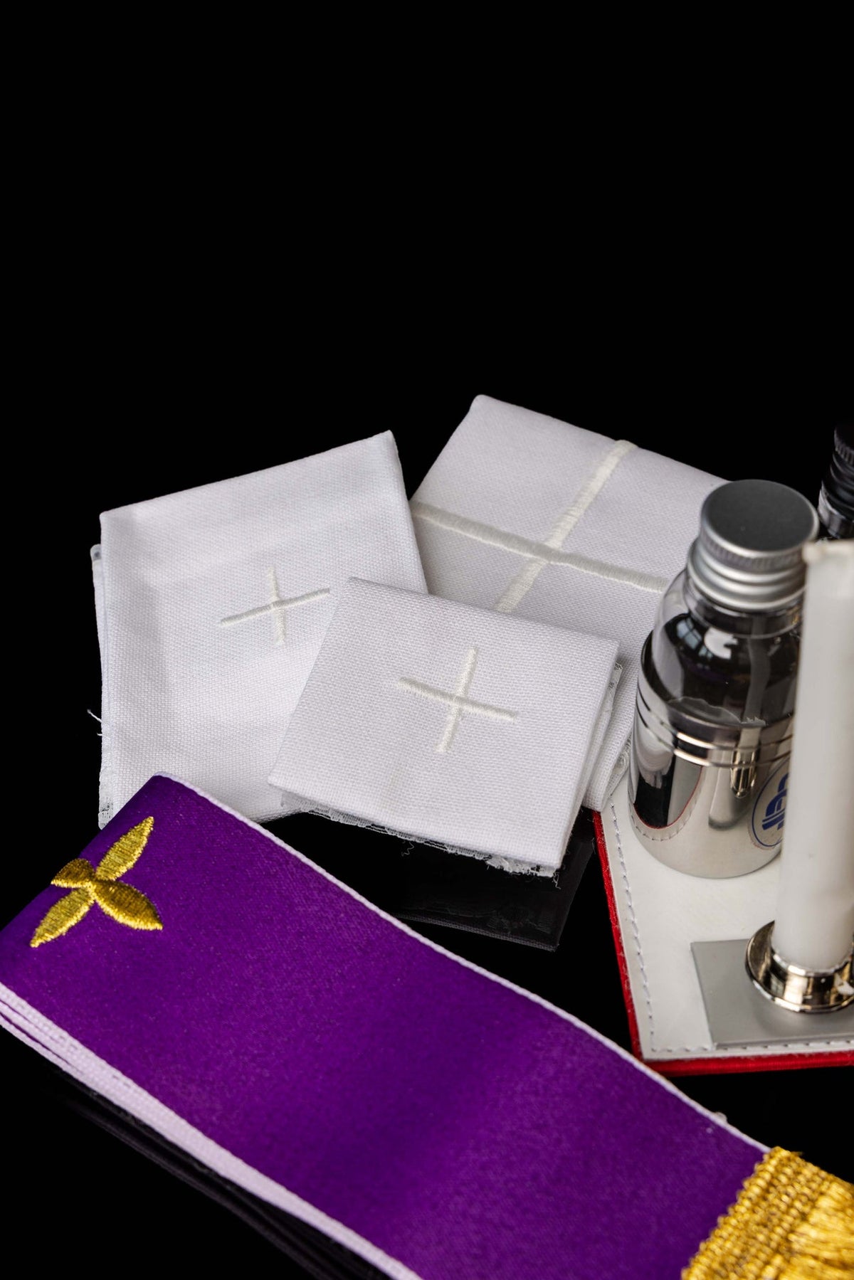 Close-up dos itens da maleta missionária, com cálice litúrgico dourado, cruz e velas