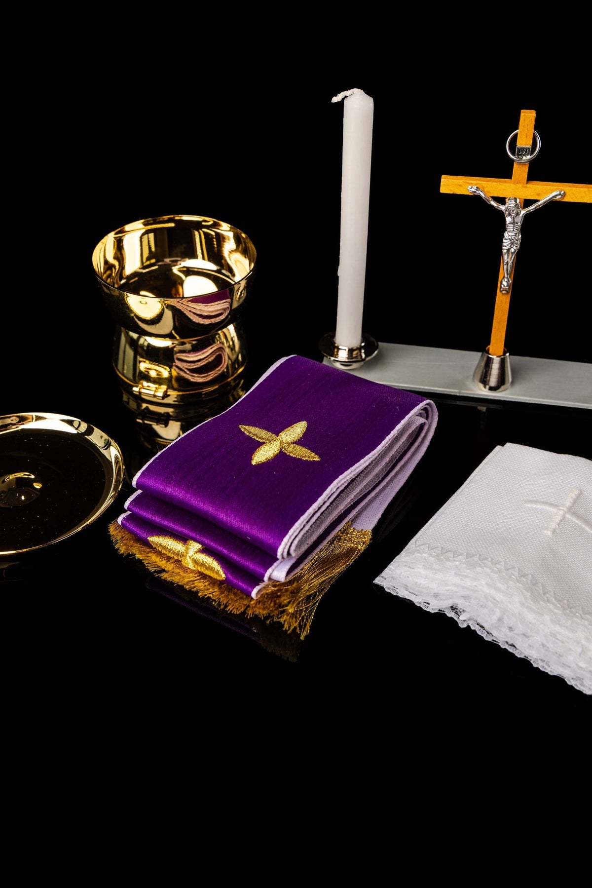 Equipamento litúrgico da maleta com cálice, vela, cruz e tecido roxo