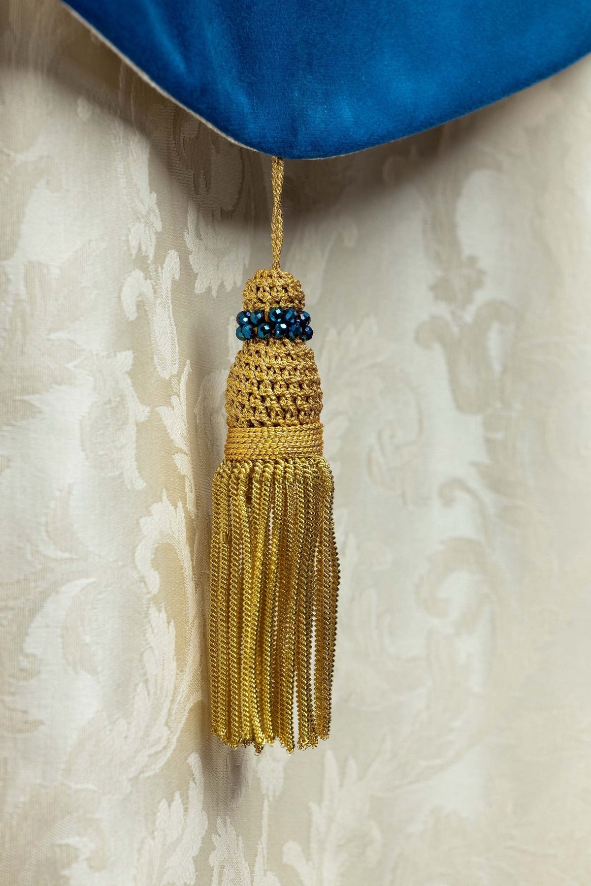 Capa de asperges litúrgica marfim ecru com borla dourada e pedras azuis em detalhe