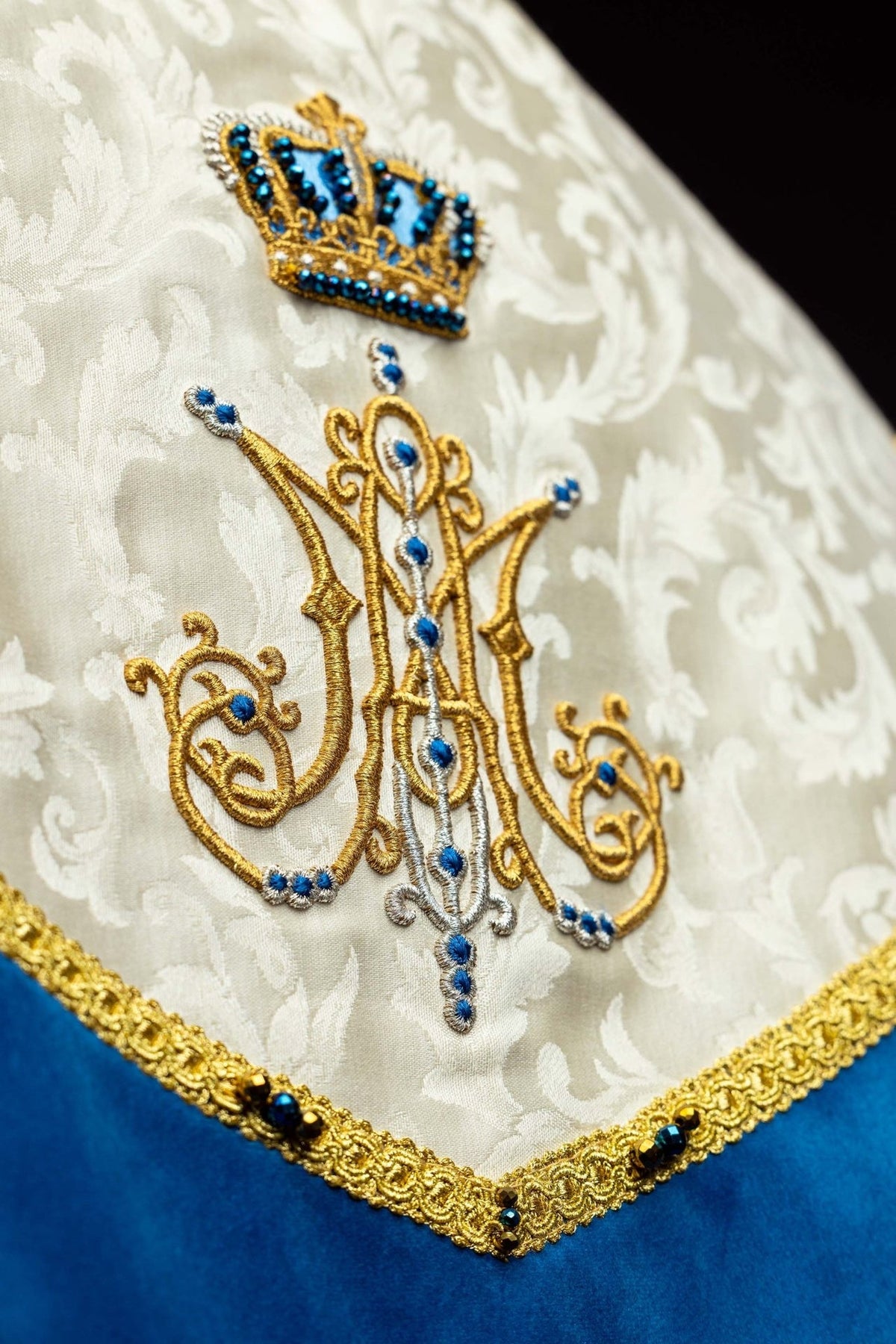 Capa de asperges litúrgica mariana, close-up do símbolo mariano em dourado, prata e azul
