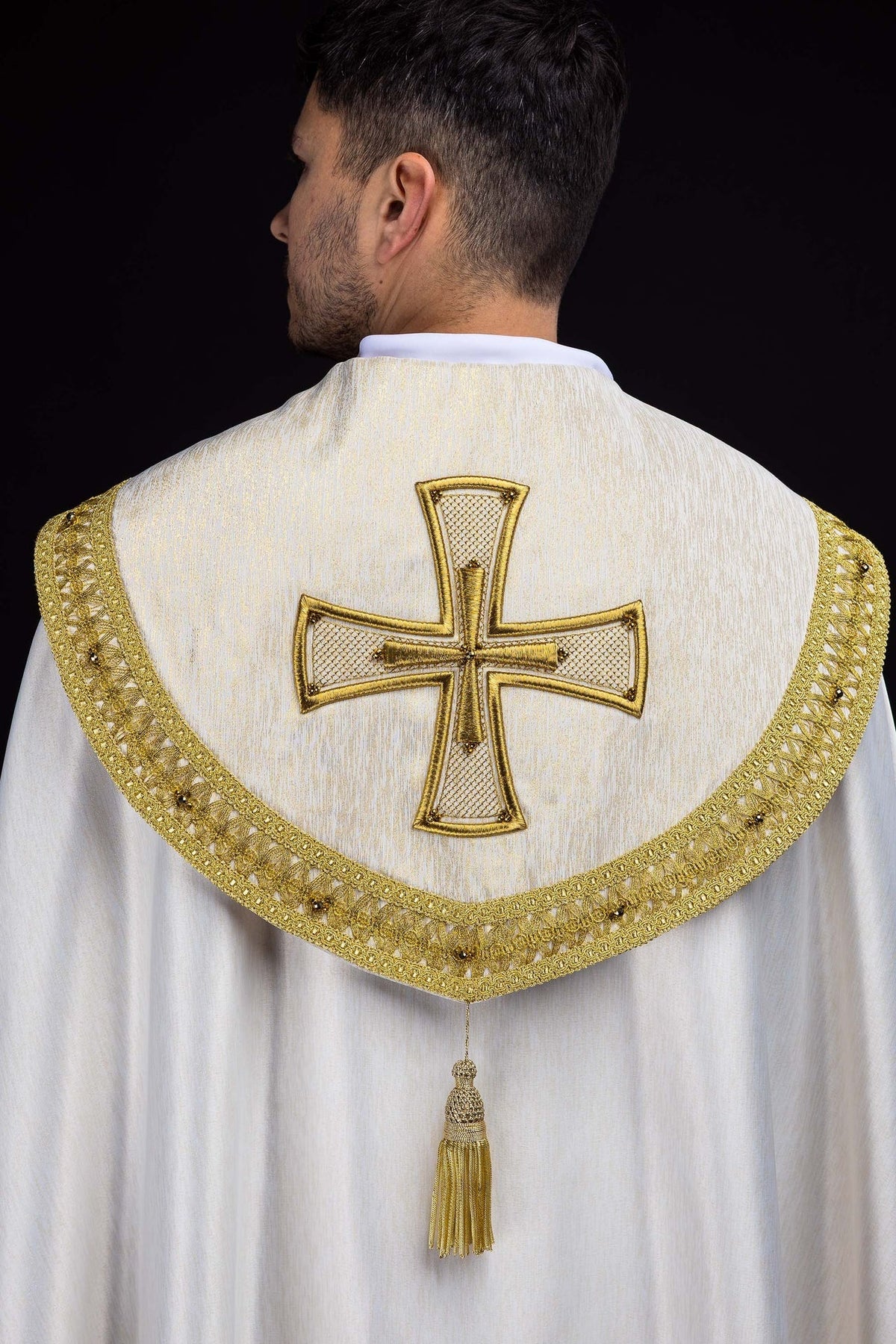 Capa de asperges artesanal com pedras naturais, vista traseira branca com galão dourado e cruz bordada