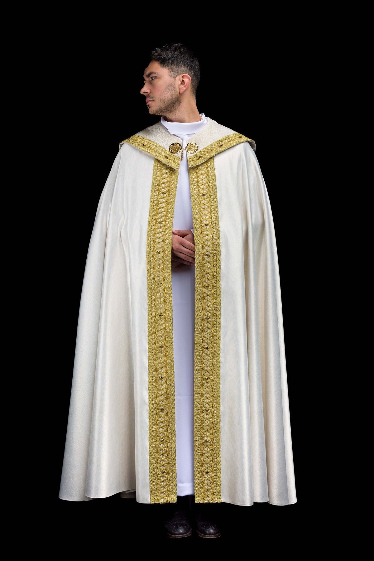Capa de asperges artesanal branca, vista frontal, com faixas douradas bordadas e fechos ornamentais