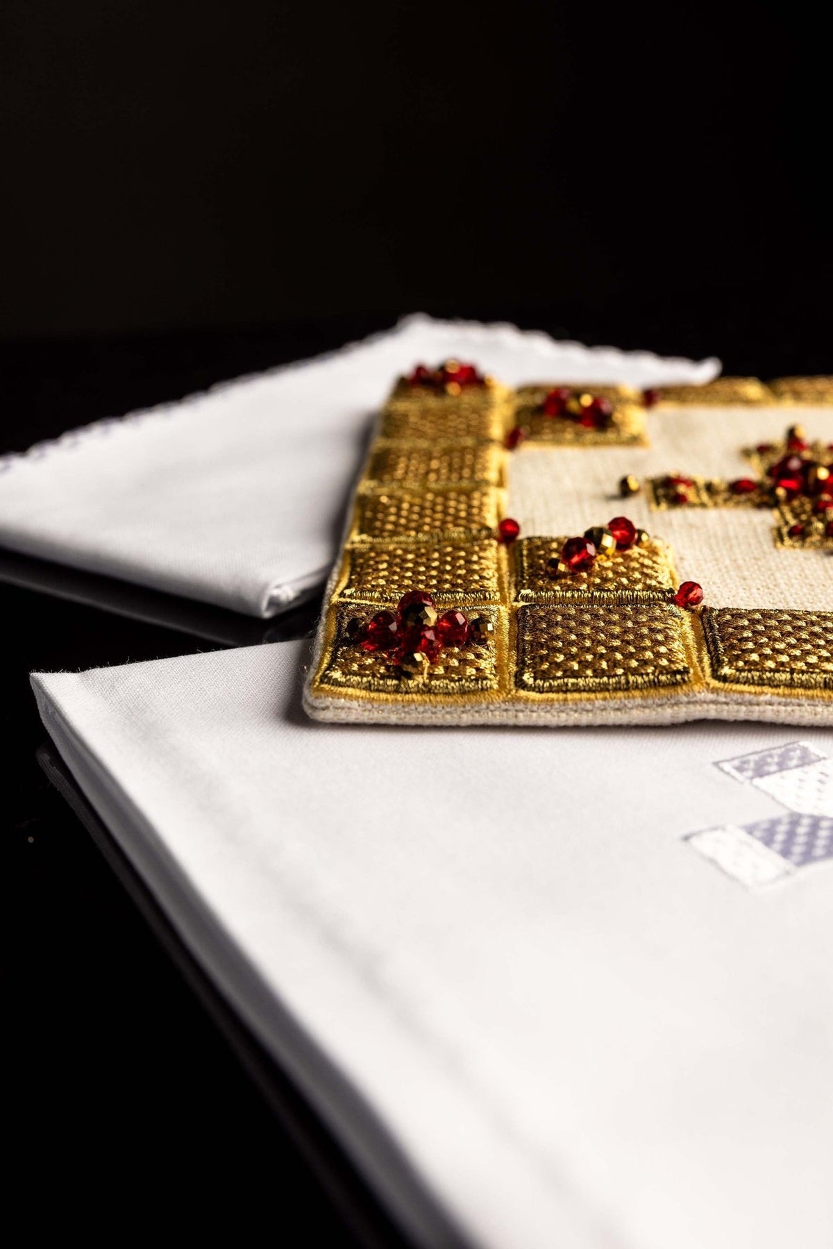 Conjunto de altar para cálice em close-up, mostrando cruz branca bordada e acabamento dourado