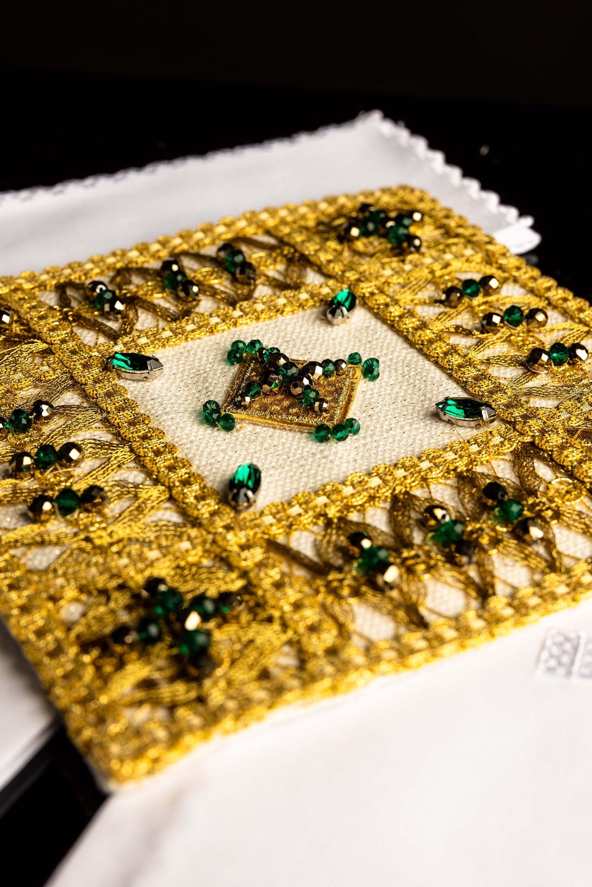 Conjunto de alfaias litúrgicas, close-up do bordado dourado com pedras verdes e pretas