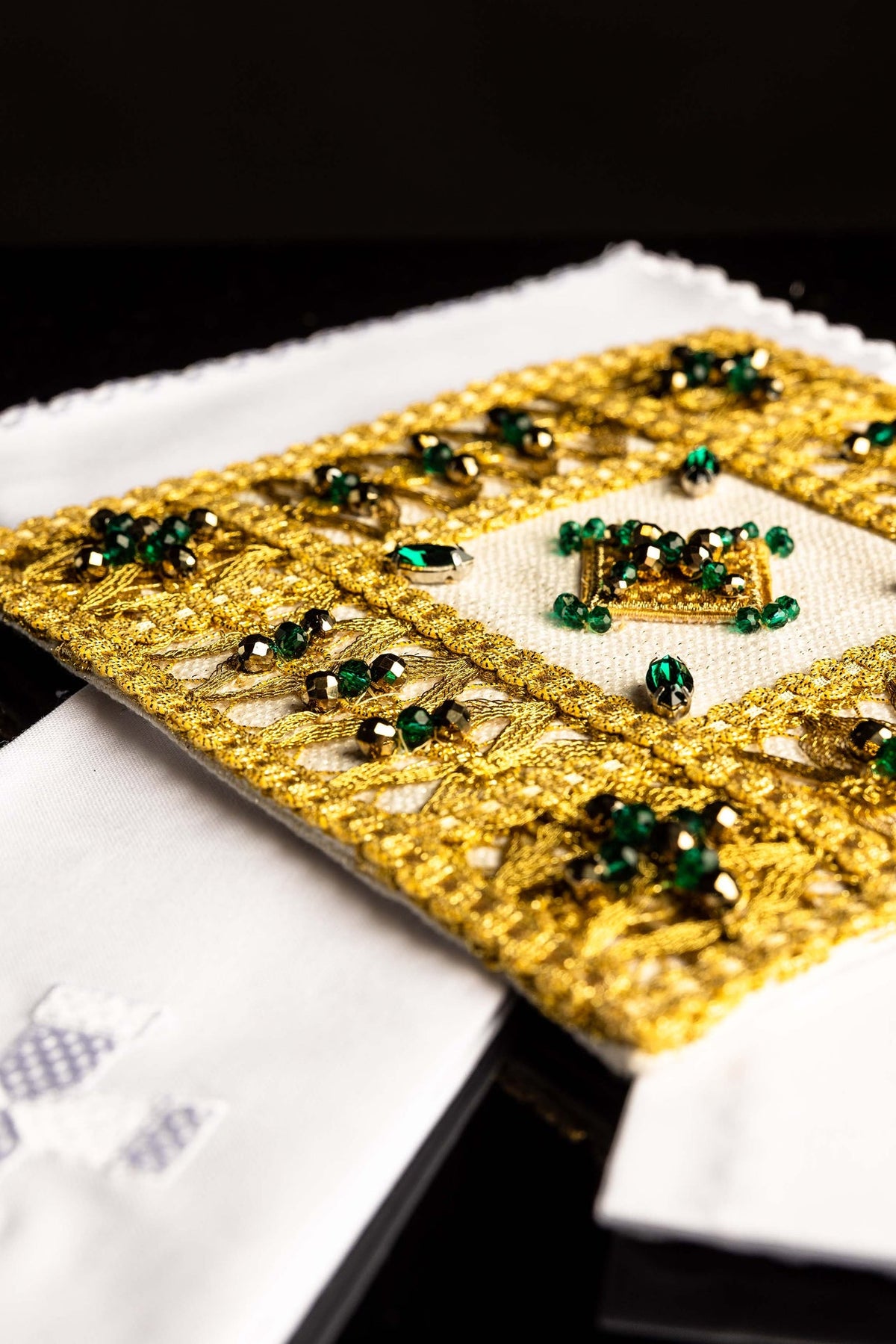 Conjunto de alfaias litúrgicas, bordado dourado com folhas e pedras verdes em close-up