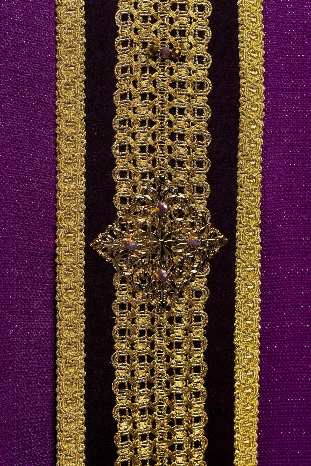 Casula roxa, close da faixa central com ornamento dourado e pedras naturais
