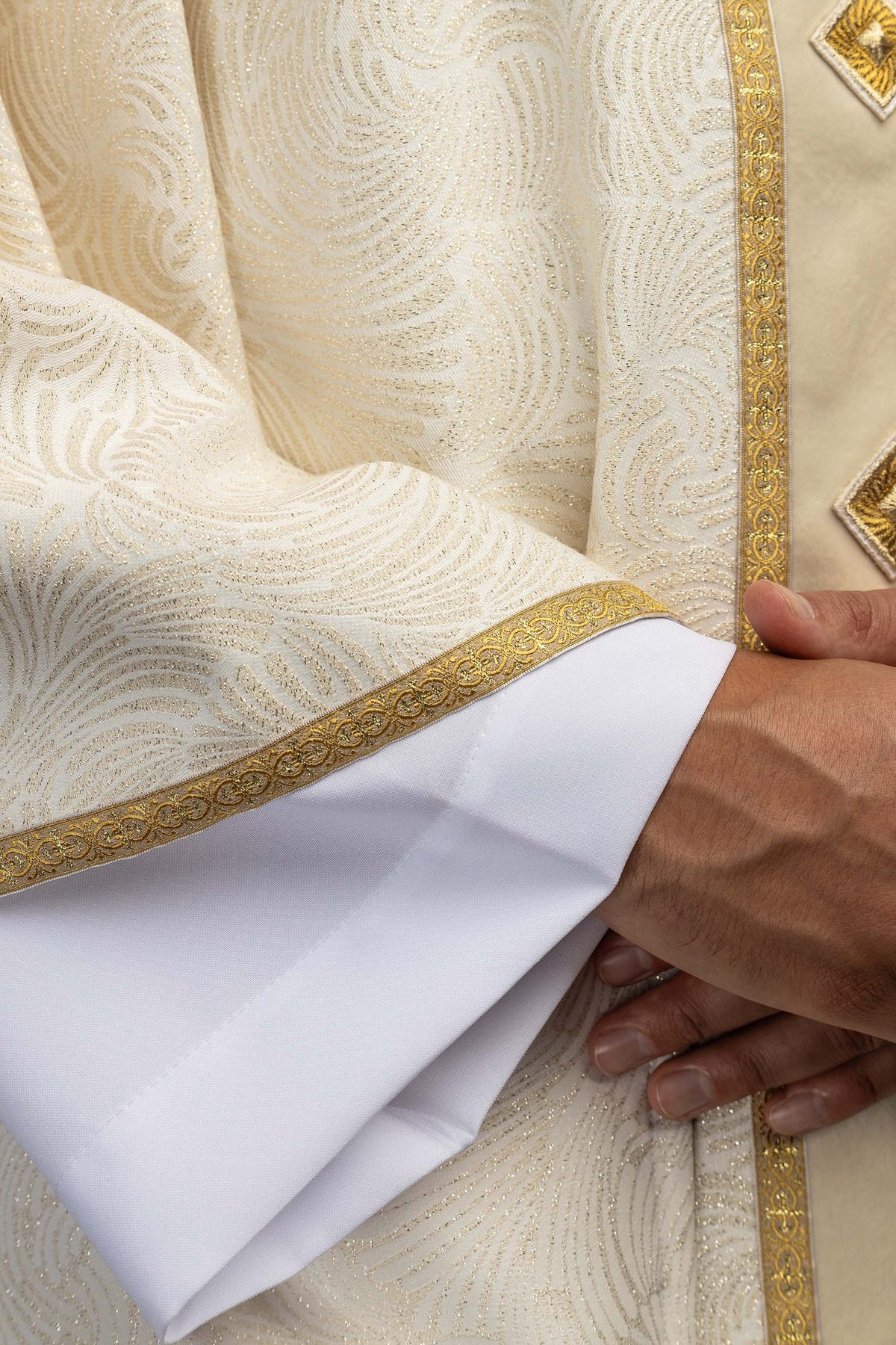 Casula em close-up do tecido jacquard e galão dourado