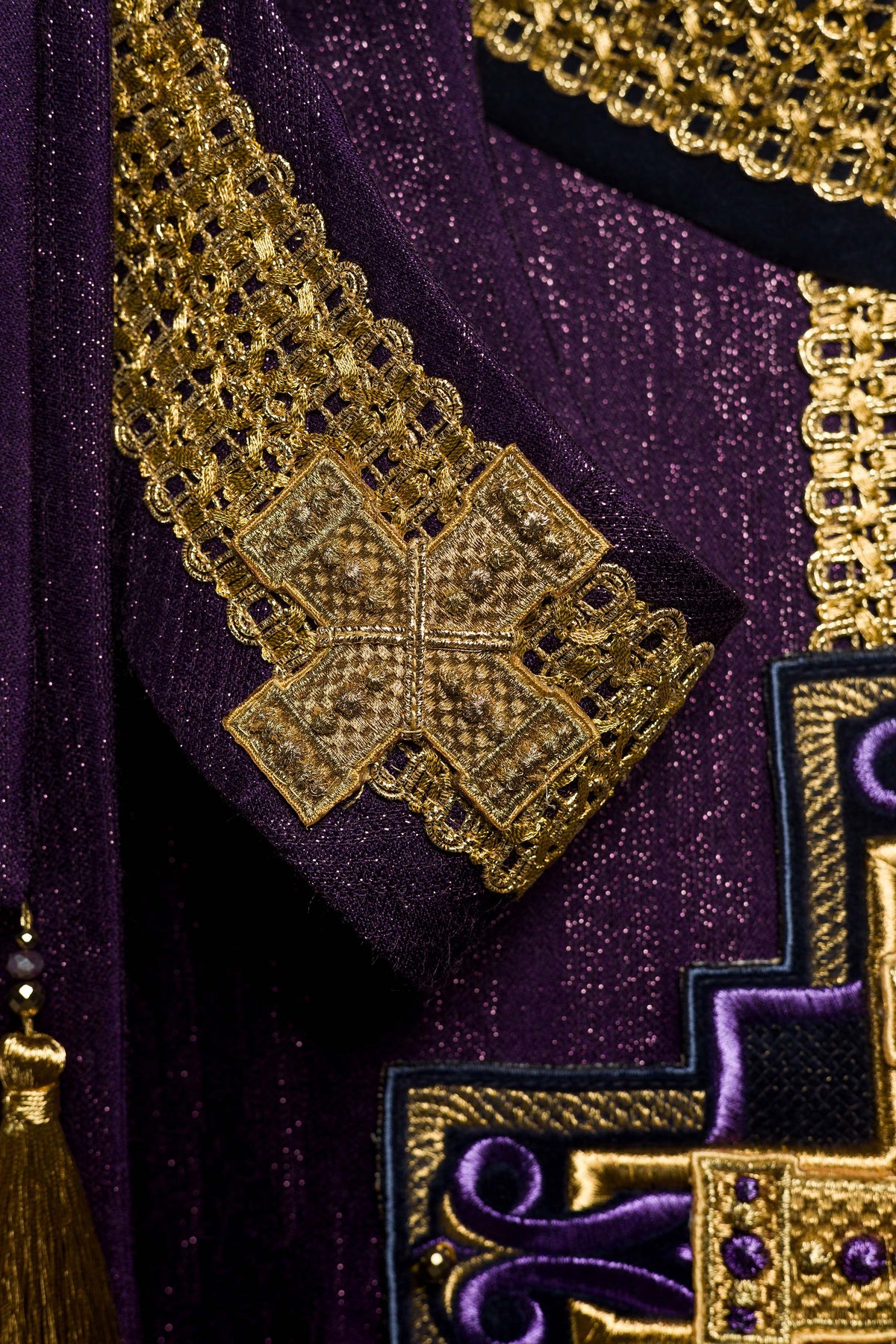 Casula roxa com detalhe do acabamento dourado em cruz na manga