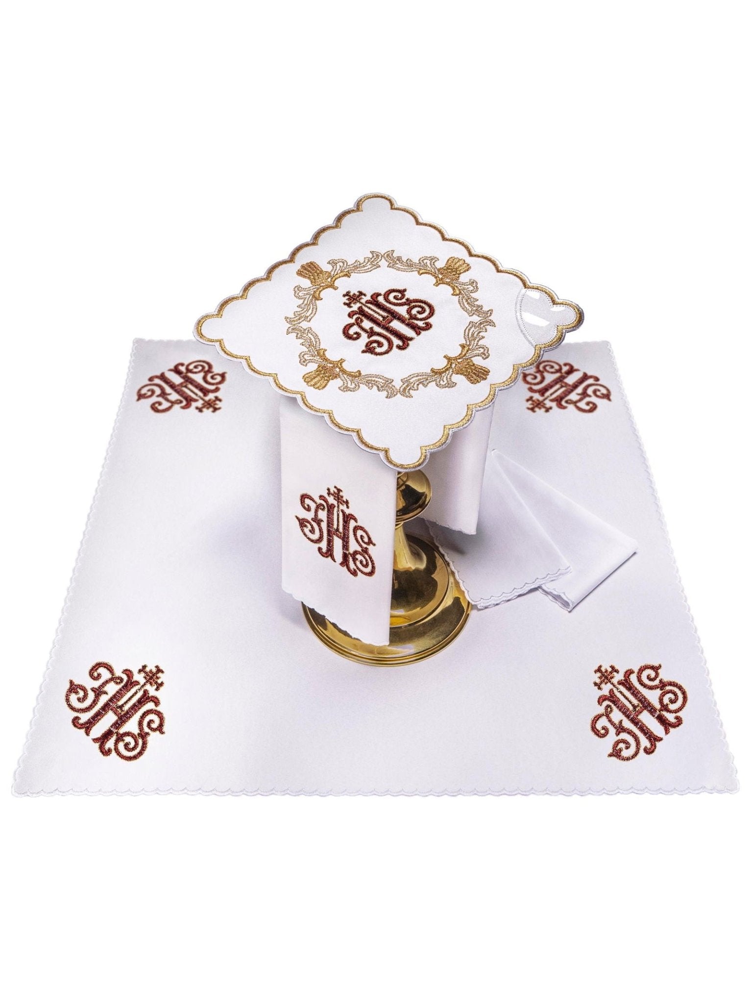 Conjunto de alfaias litúrgicas branco com bordado IHS em vermelho e dourado, incluindo pala, corporal, sanguíneo e manutérgio.