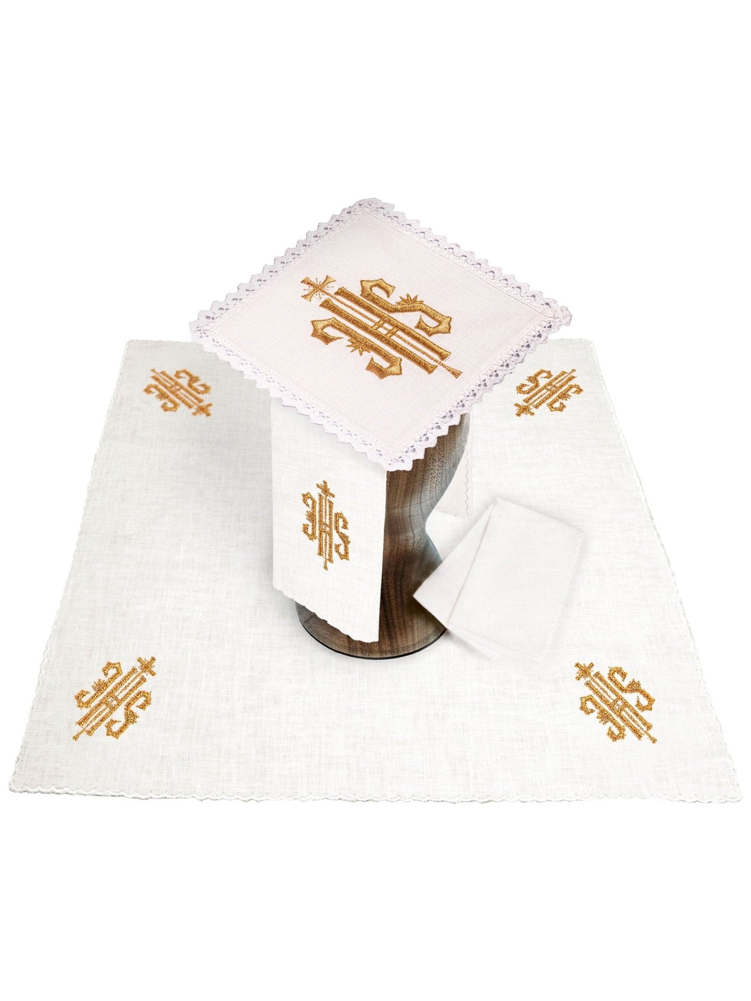 Conjunto de alfaias litúrgicas em linho branco, bordado com o símbolo IHS dourado.