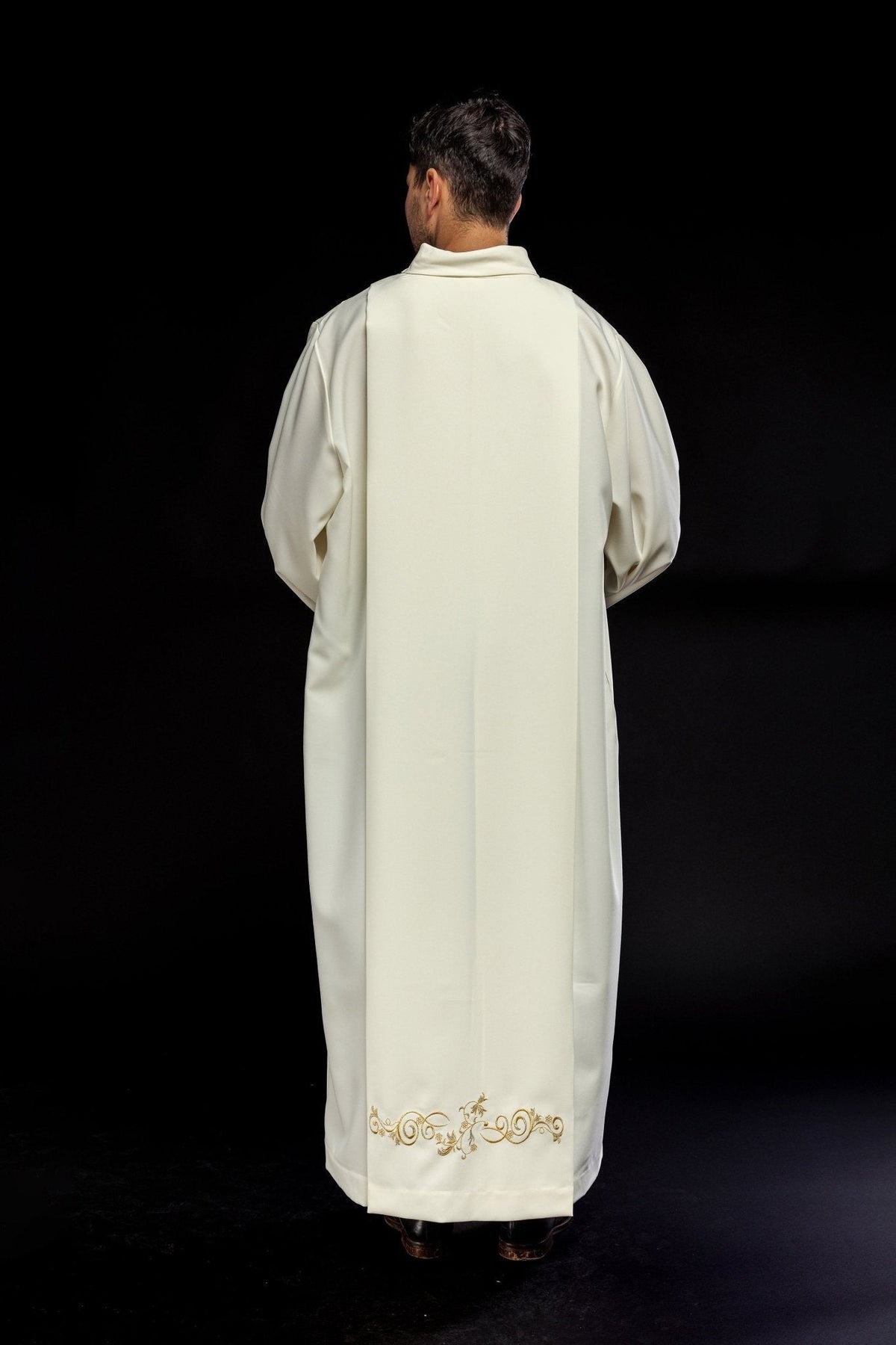 Alva sacerdotal creme em vista traseira, com bordado floral dourado na barra