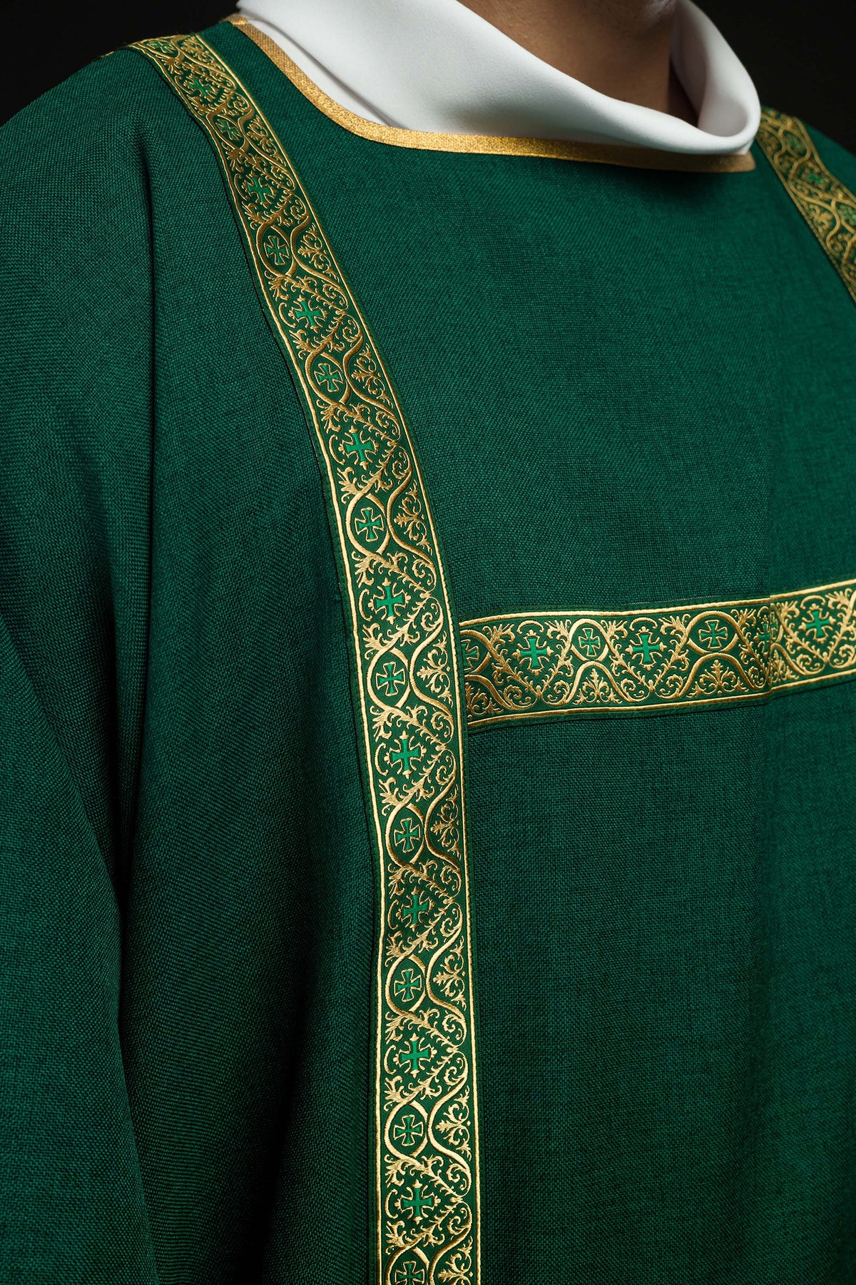 Dalmática verde com galões jacquard dourados em close na faixa frontal com cruzes