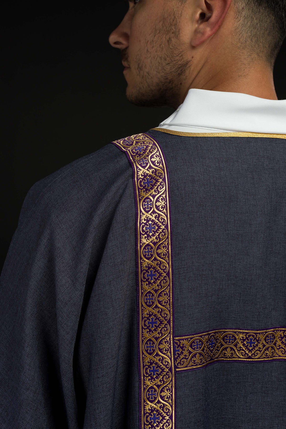 Dalmática roxa vista de trás, com fitas jacquard douradas