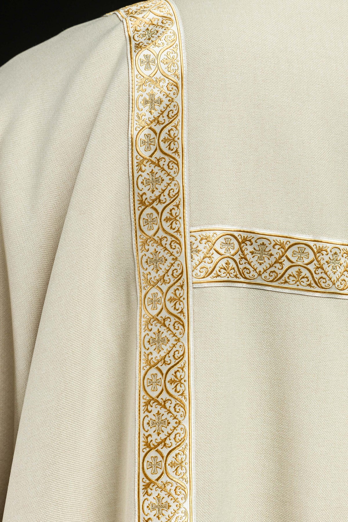 Dalmática creme com fita jacquard dourada em close-up frontal