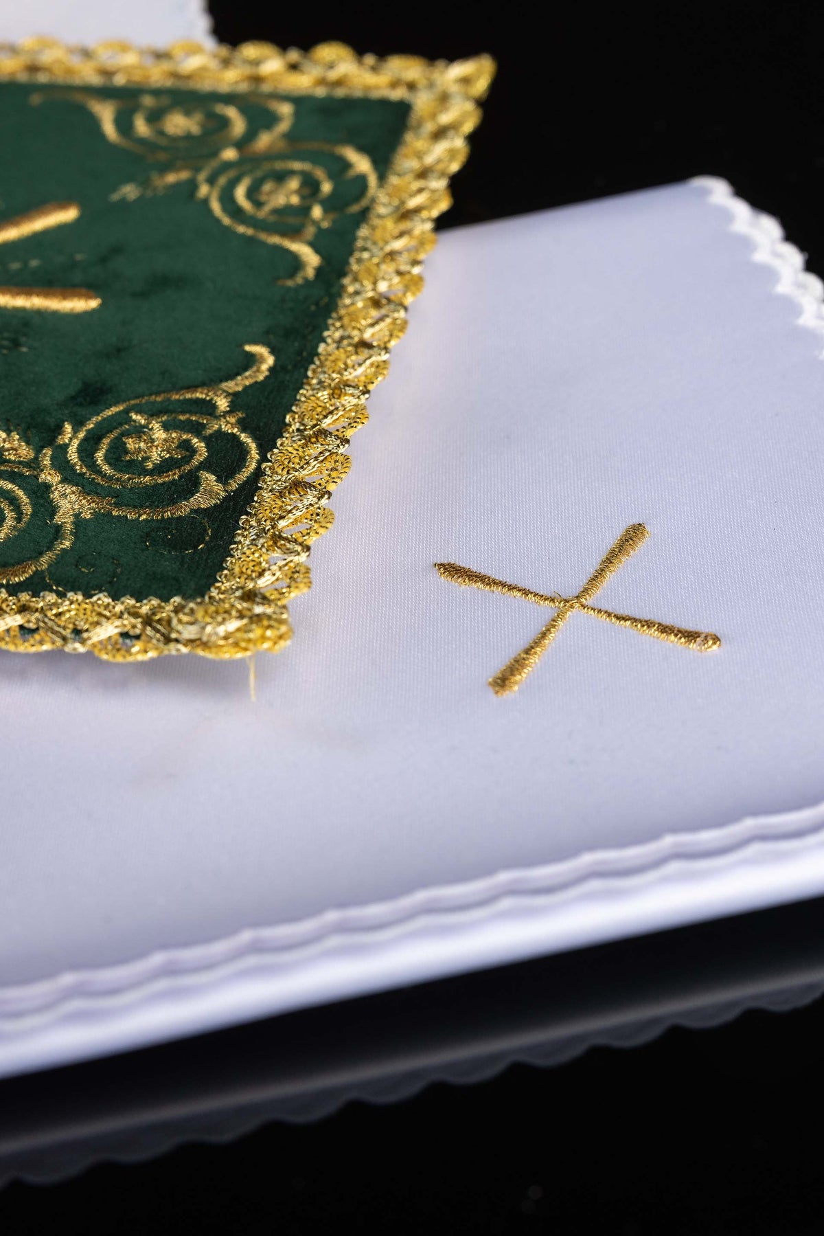 Alfaias litúrgicas com detalhe da pala verde bordada e tecido branco com cruz dourada