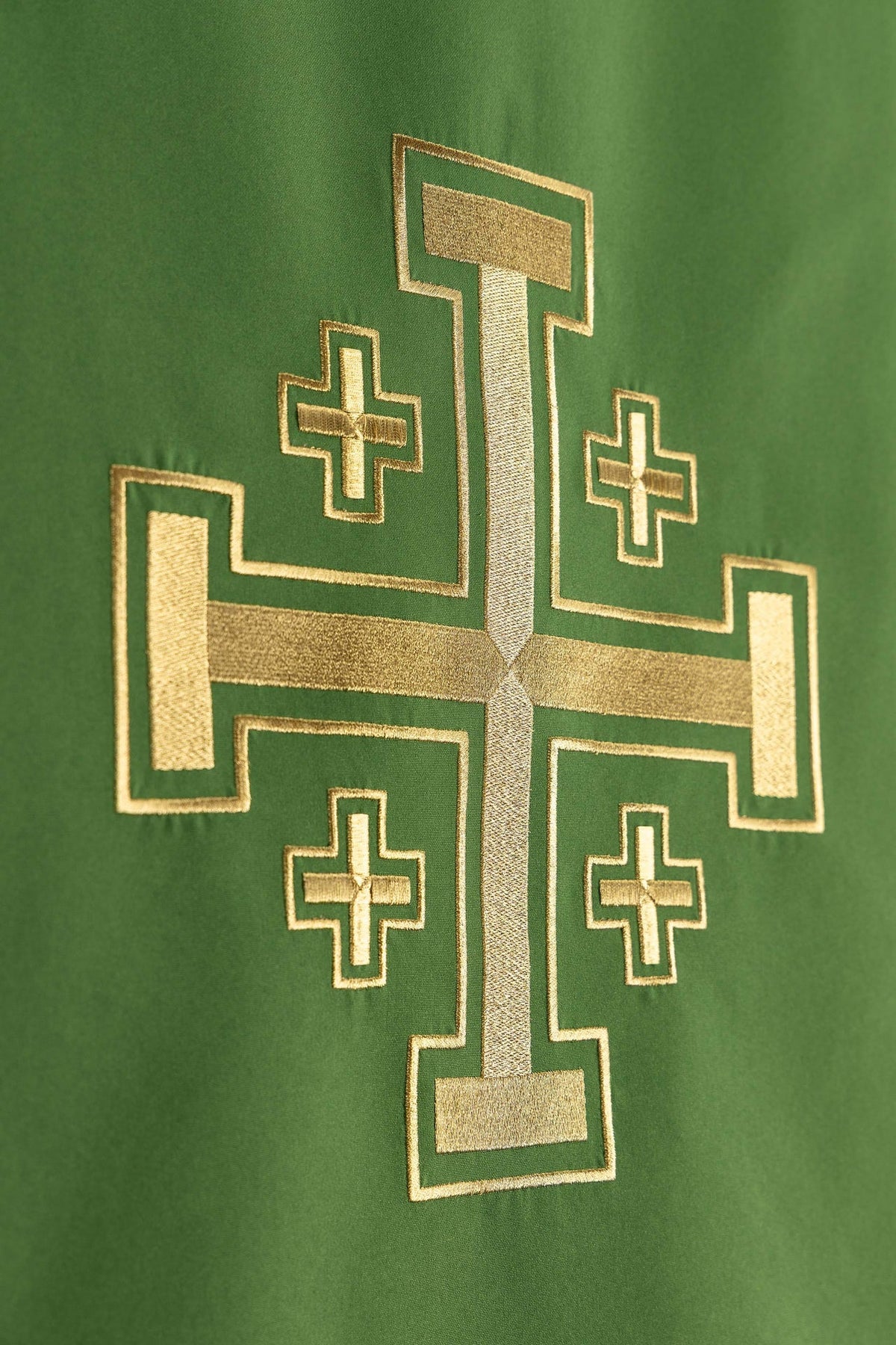 Toalha de ambão verde em close-up do bordado dourado da Cruz de Jerusalém