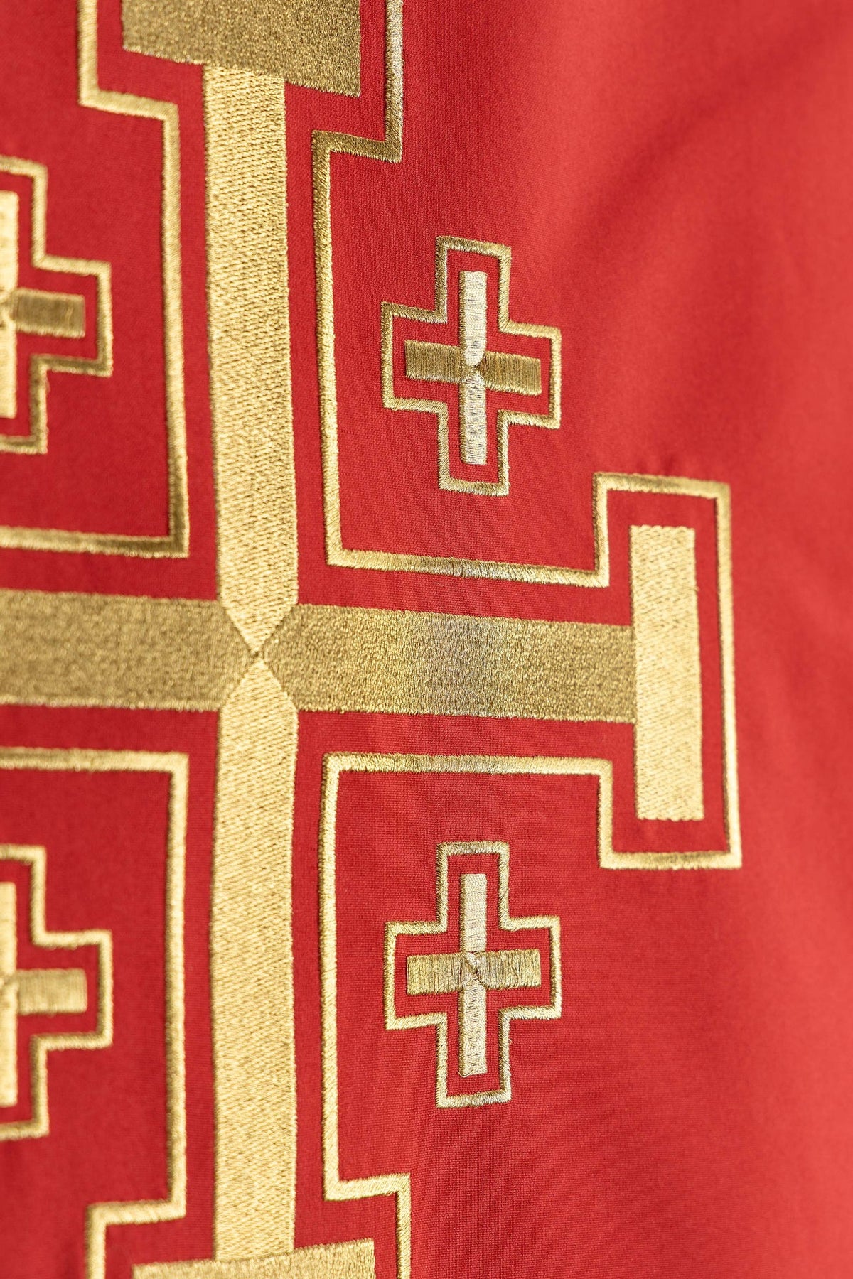 Toalha de ambão vermelha em close-up dos detalhes dourados da cruz bordada