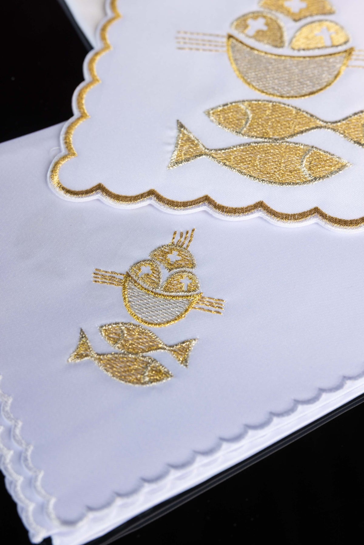 Conjunto de alfaias Pão e Peixes em vista inclinada, destacando bordados e acabamento ondulado