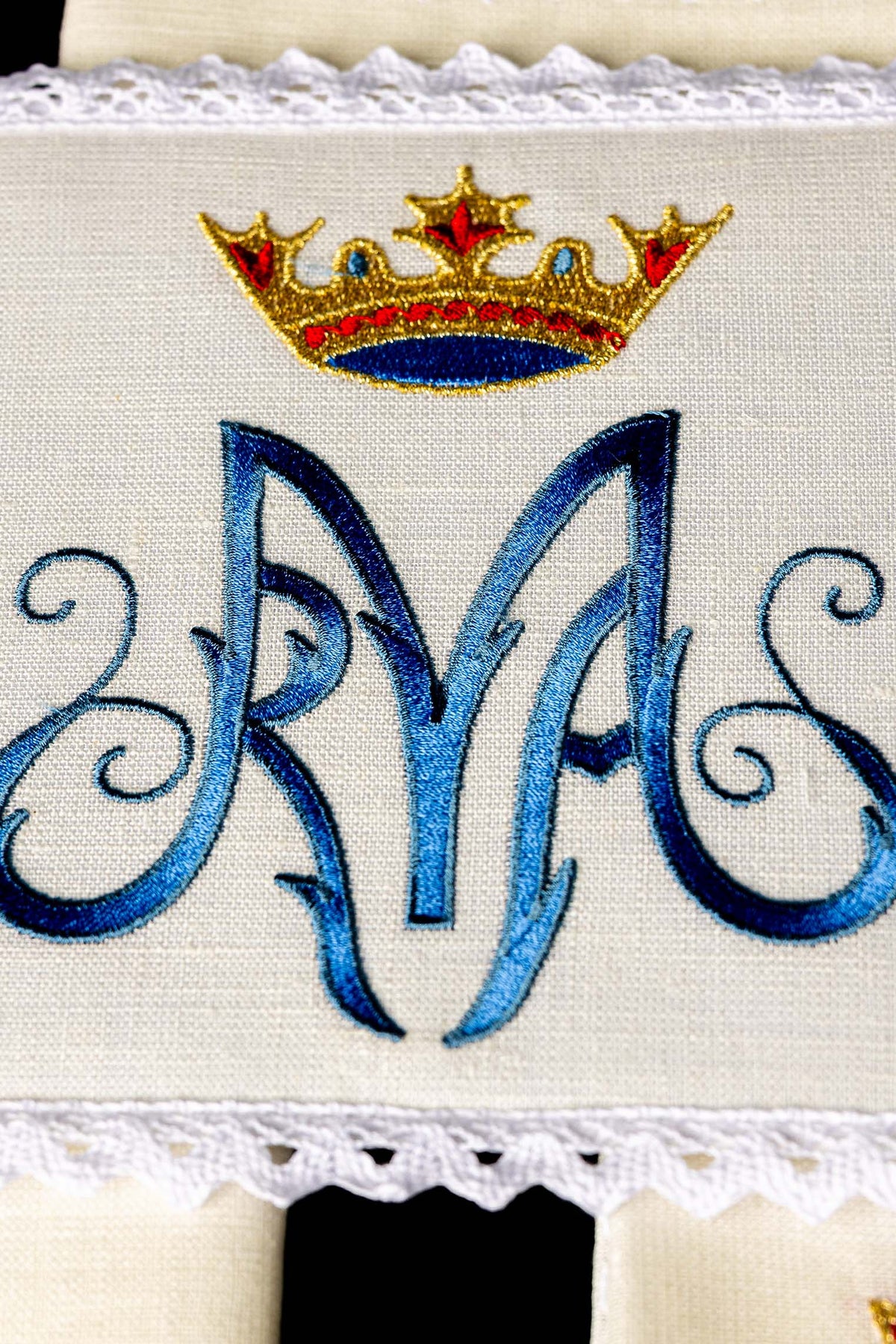 Alfaias litúrgicas com close-up da coroa dourada e monograma mariano azul